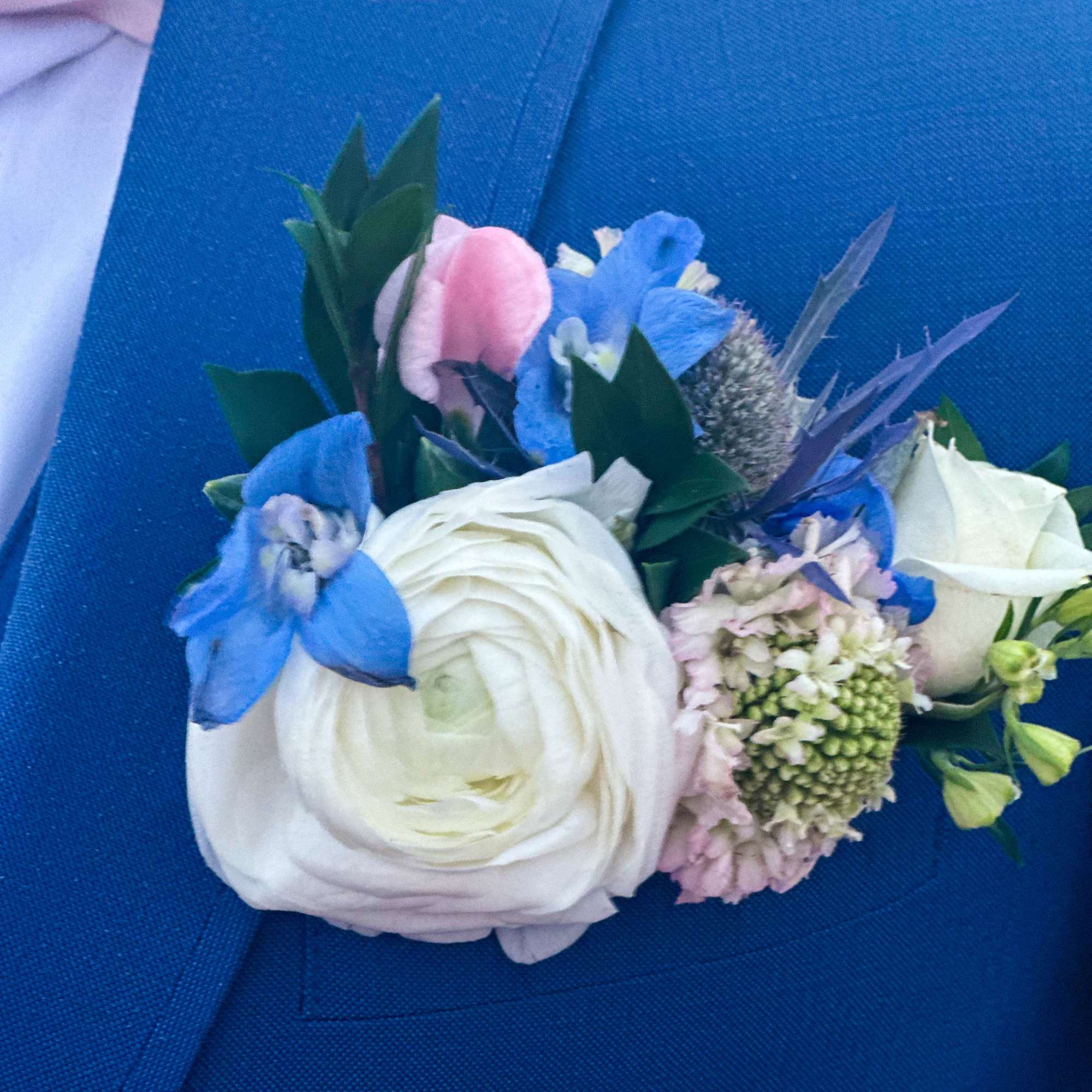Blue and white boutonniere with a large white bloom