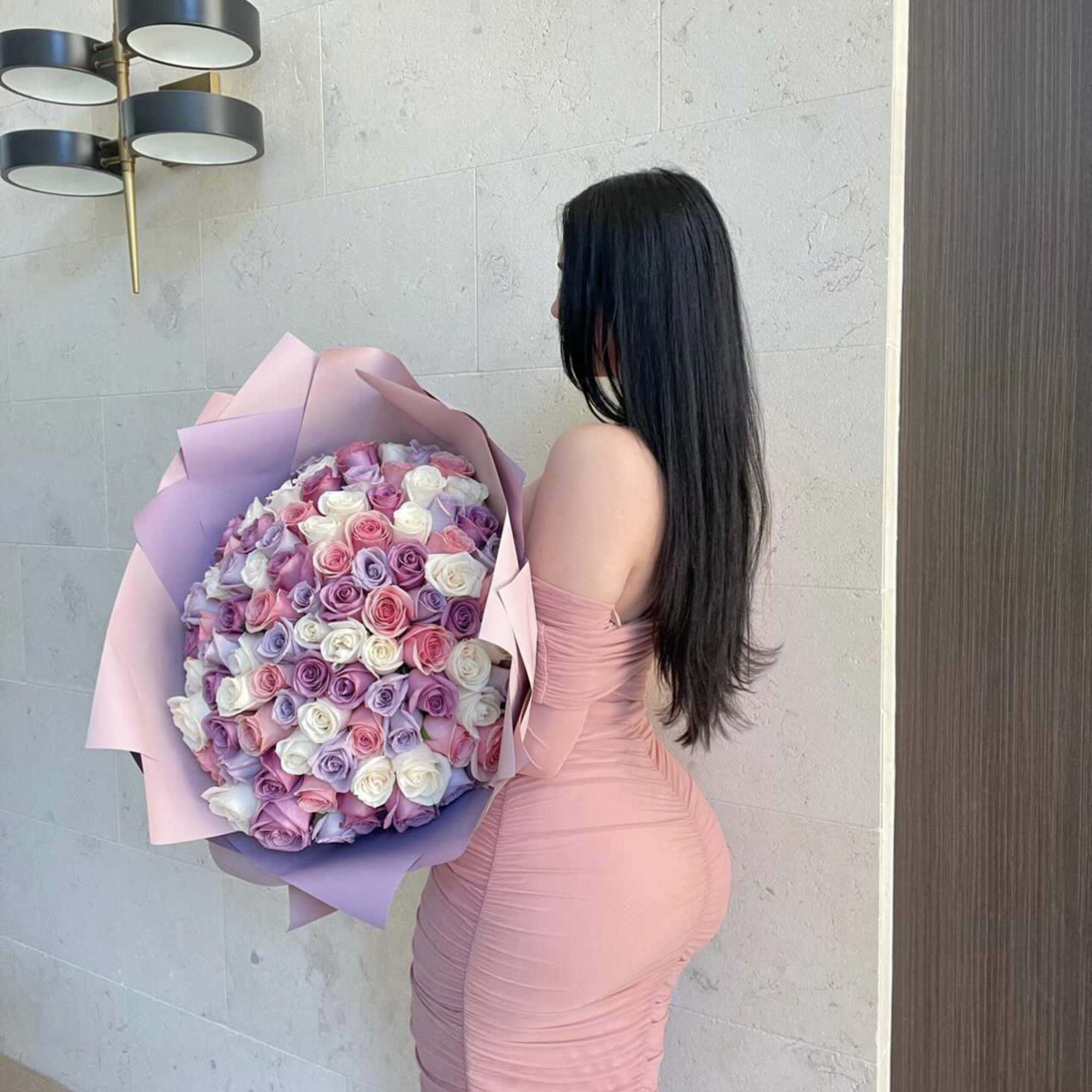 Large bouquet of pastel roses wrapped in pink and lavender paper