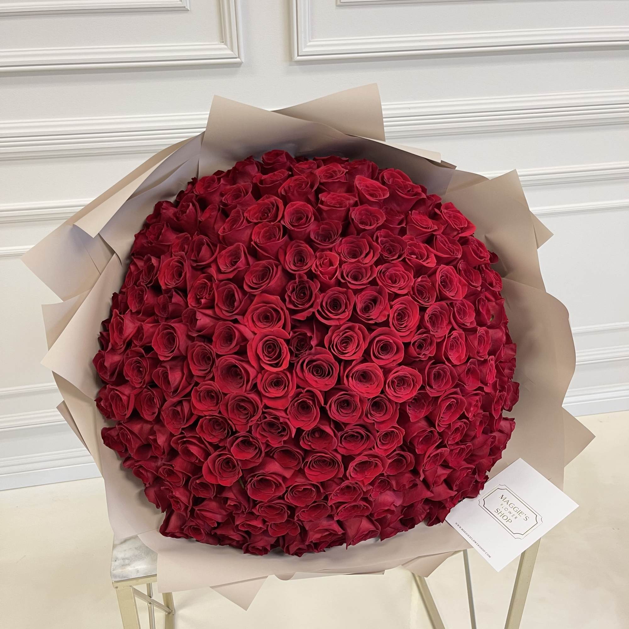 Large bouquet of red roses wrapped in beige paper