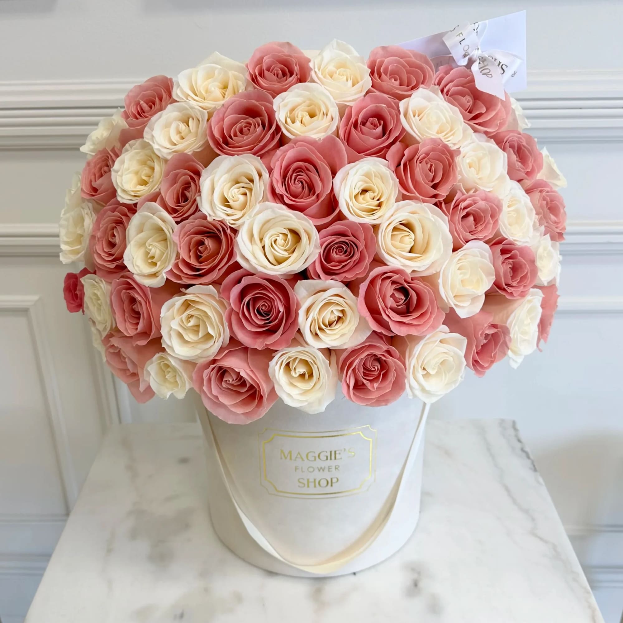 Bouquet of pink and cream roses in a white hat box