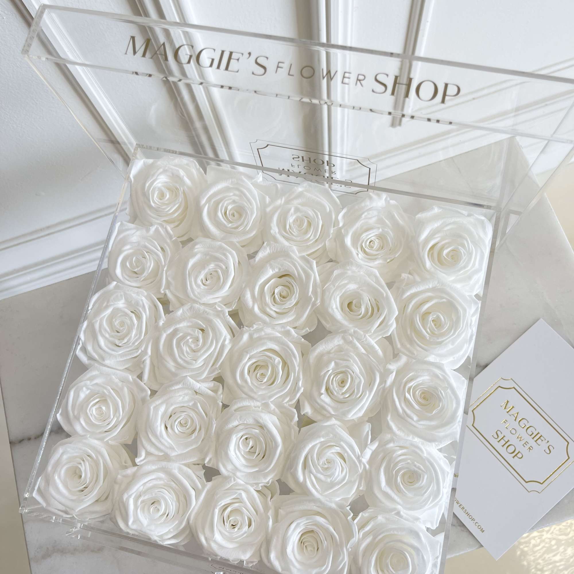 Clear box filled with white roses