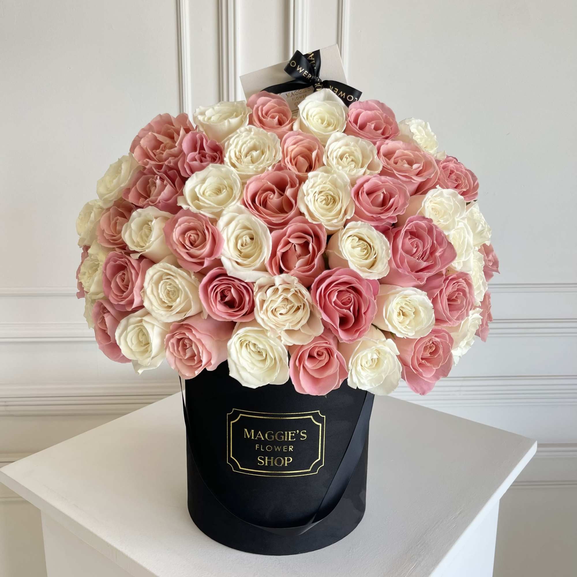Bouquet of pink and white roses in a black hat box