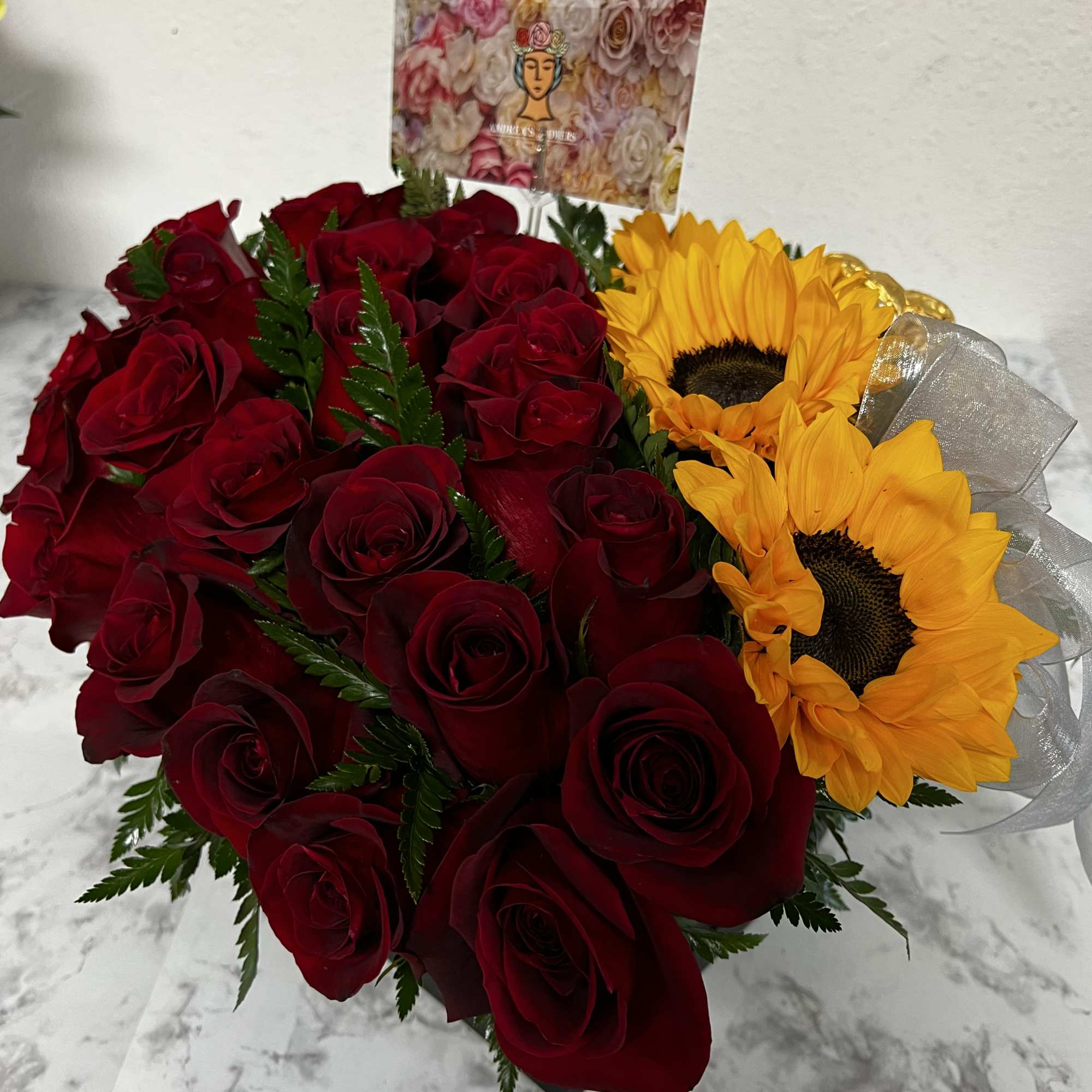 Bouquet of red roses and yellow sunflowers with a ribbon