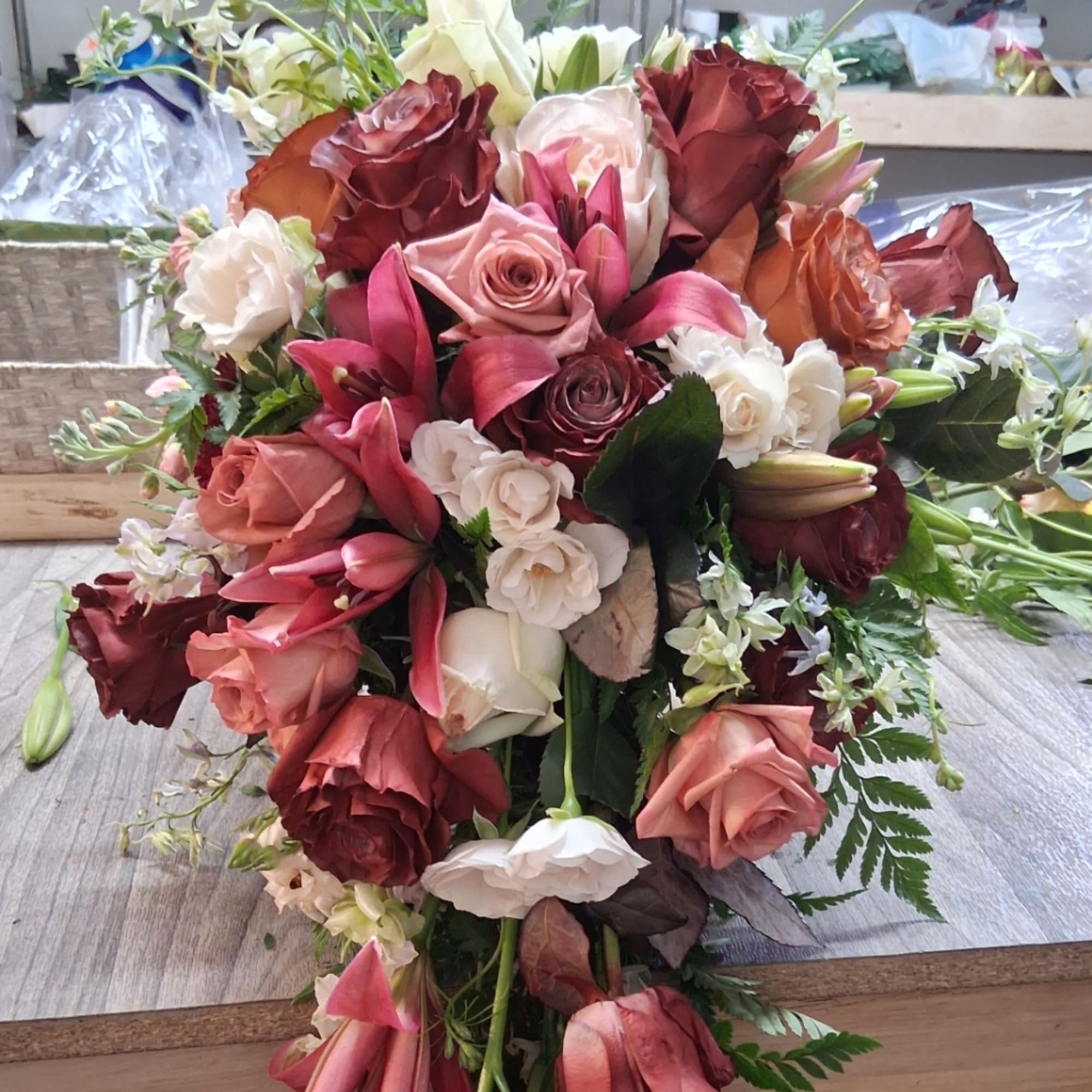 Wedding bouquet of roses and lilies in pink, white, and burgundy tones