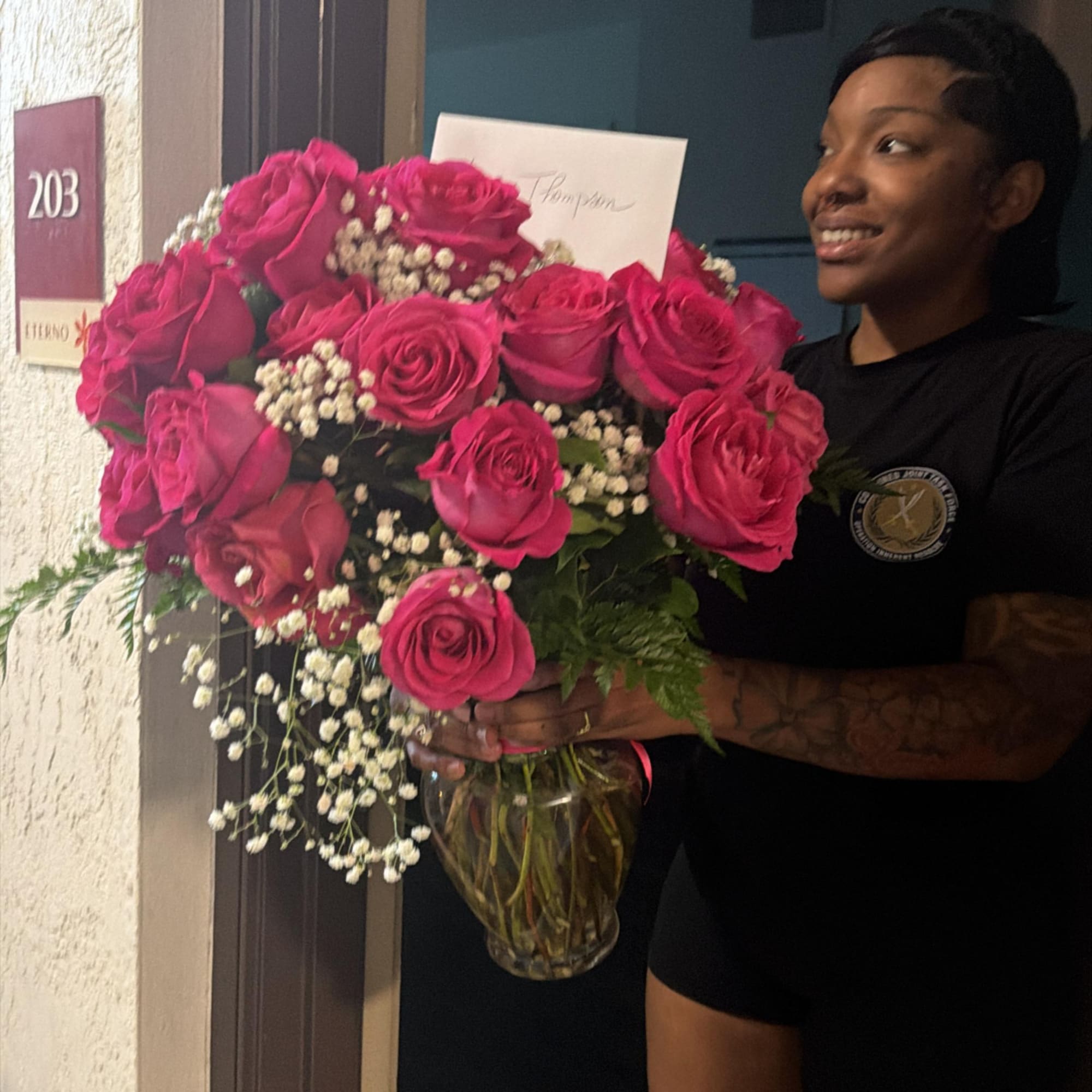 Large bouquet of hot pink roses with baby's breath in a glass vase