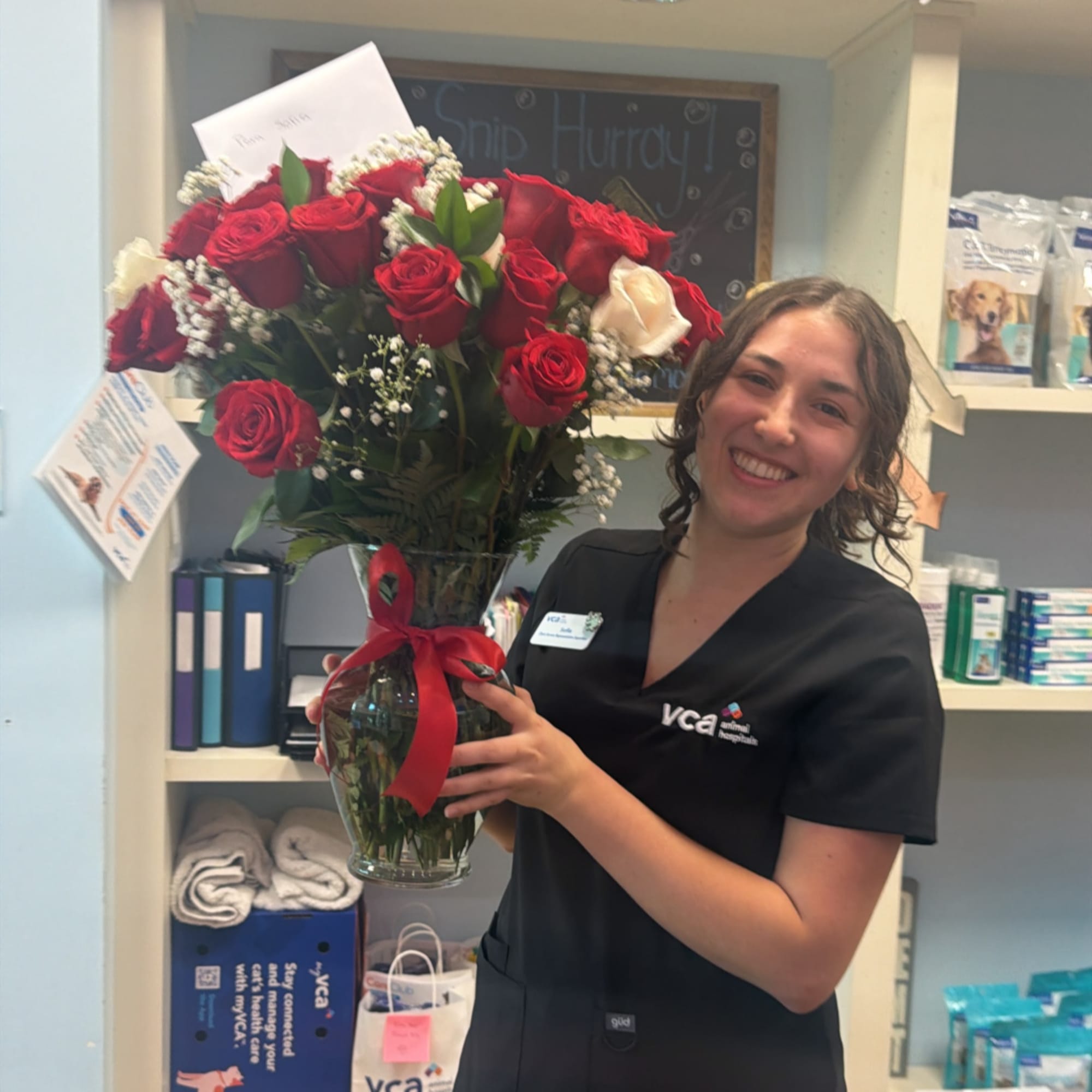 Woman holding a vase of red and white roses