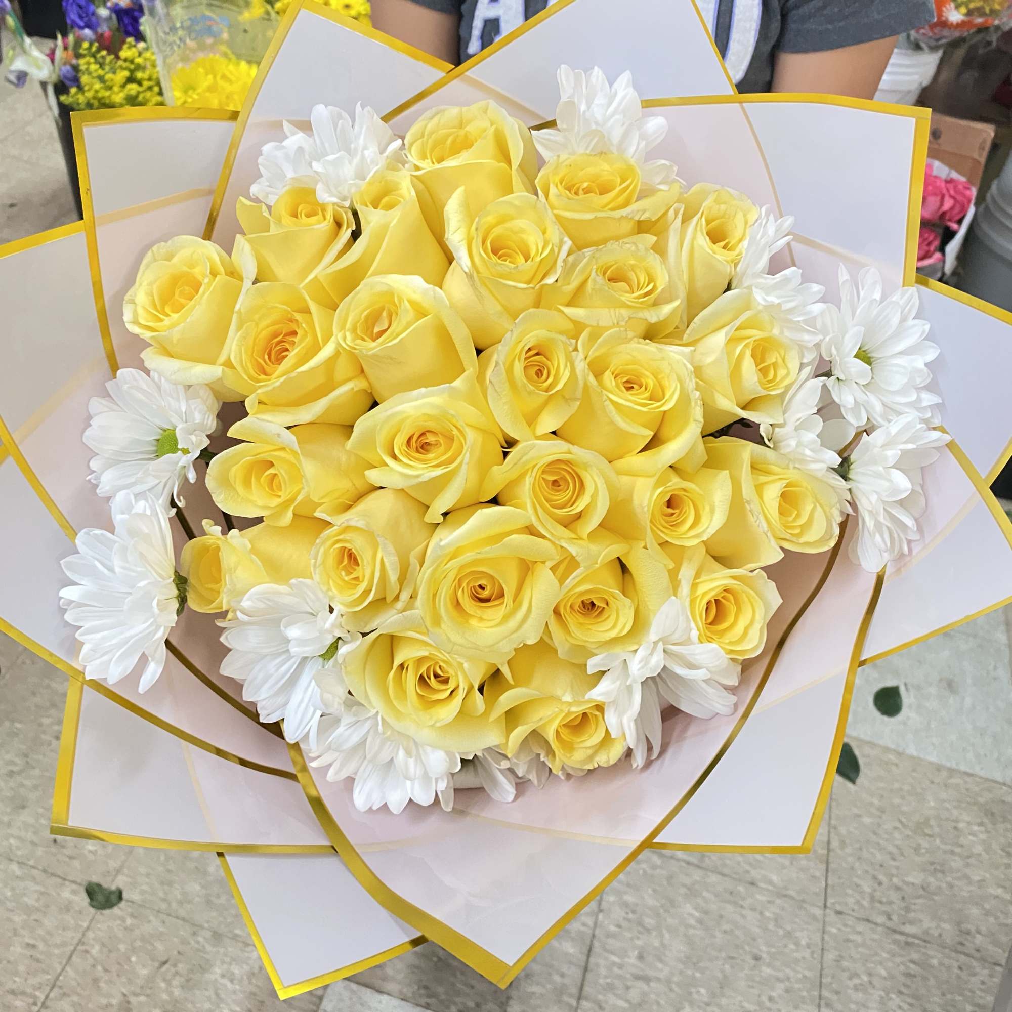 Yellow rose bouquet with white daisies wrapped in white paper