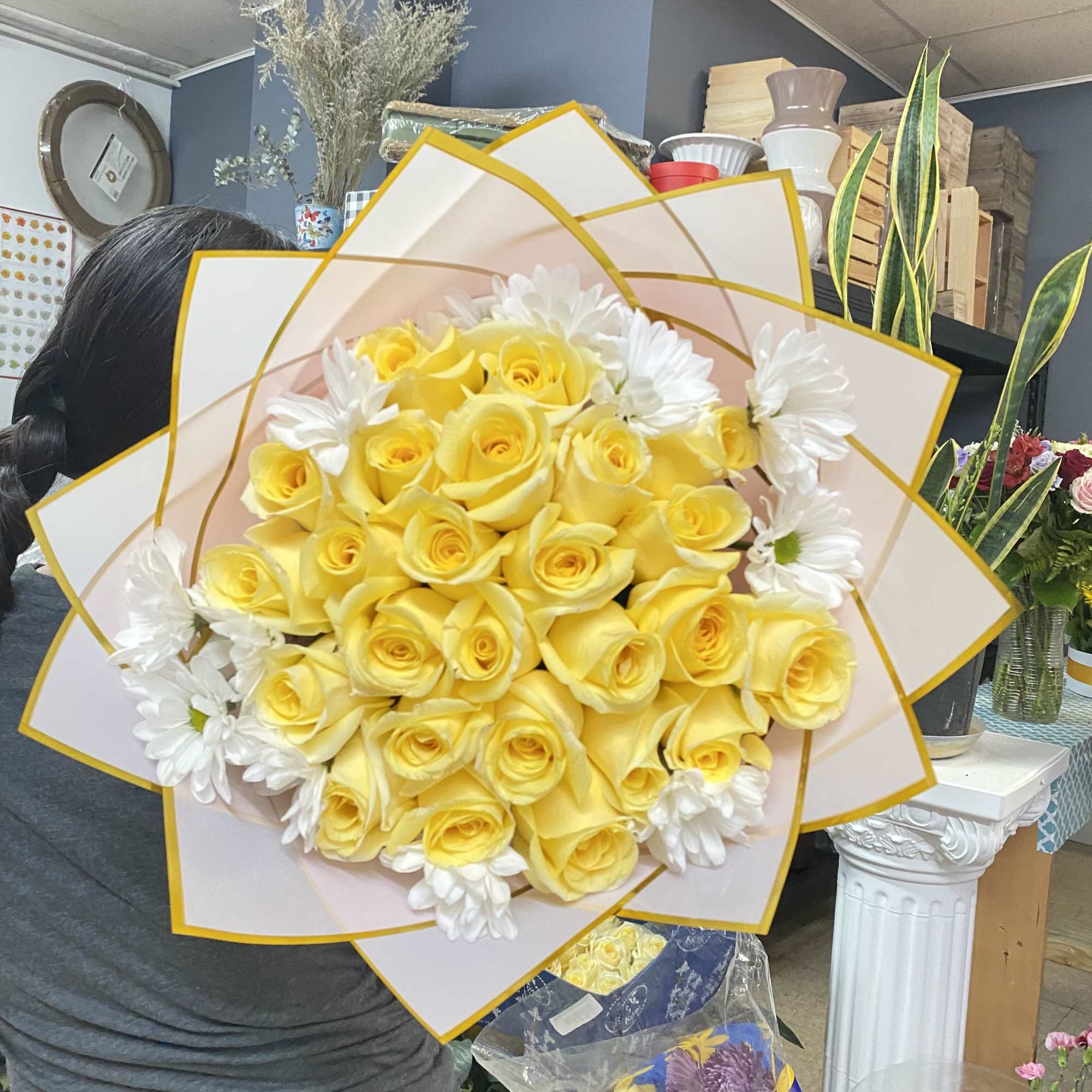 Yellow rose bouquet with white daisies wrapped in pale pink paper