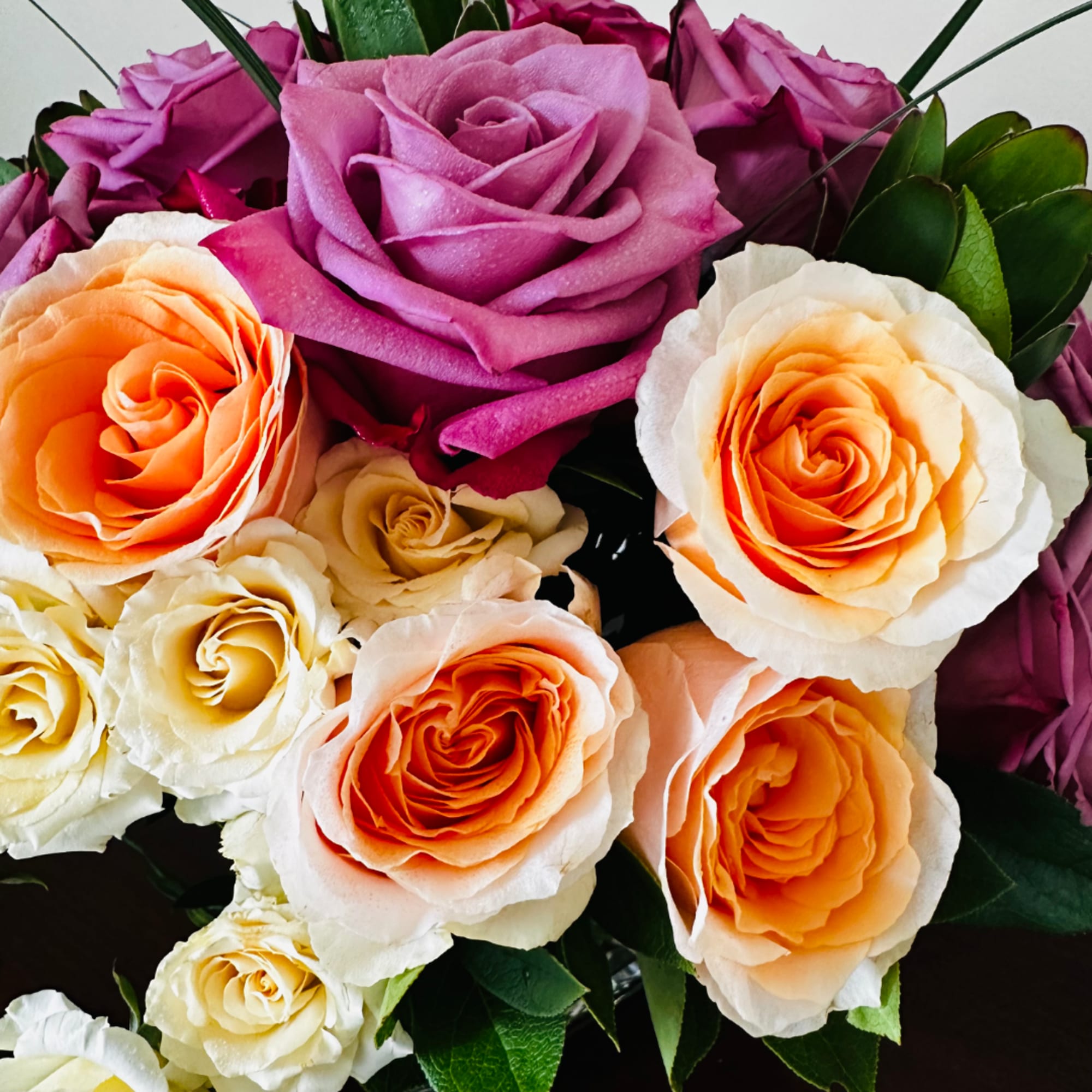 Bouquet of roses in pink, purple, peach, and cream tones