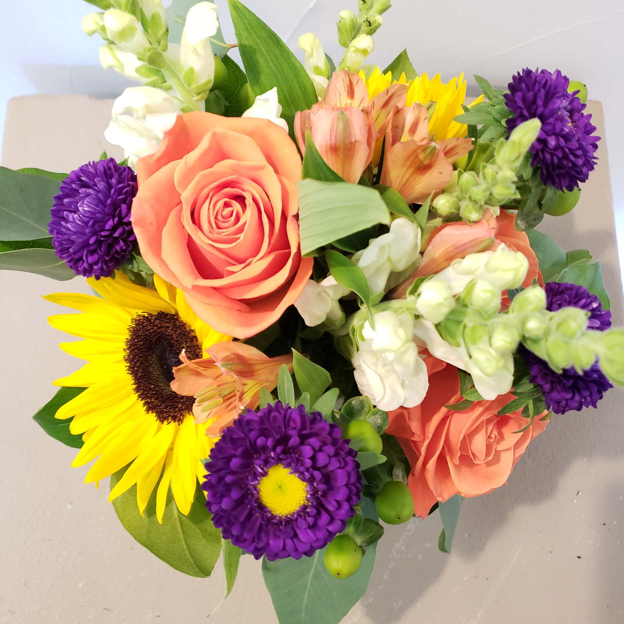 4" cylinder vase with alstromeria, aster, sunflowers, roses and snap dragons. , photo 2 of 2