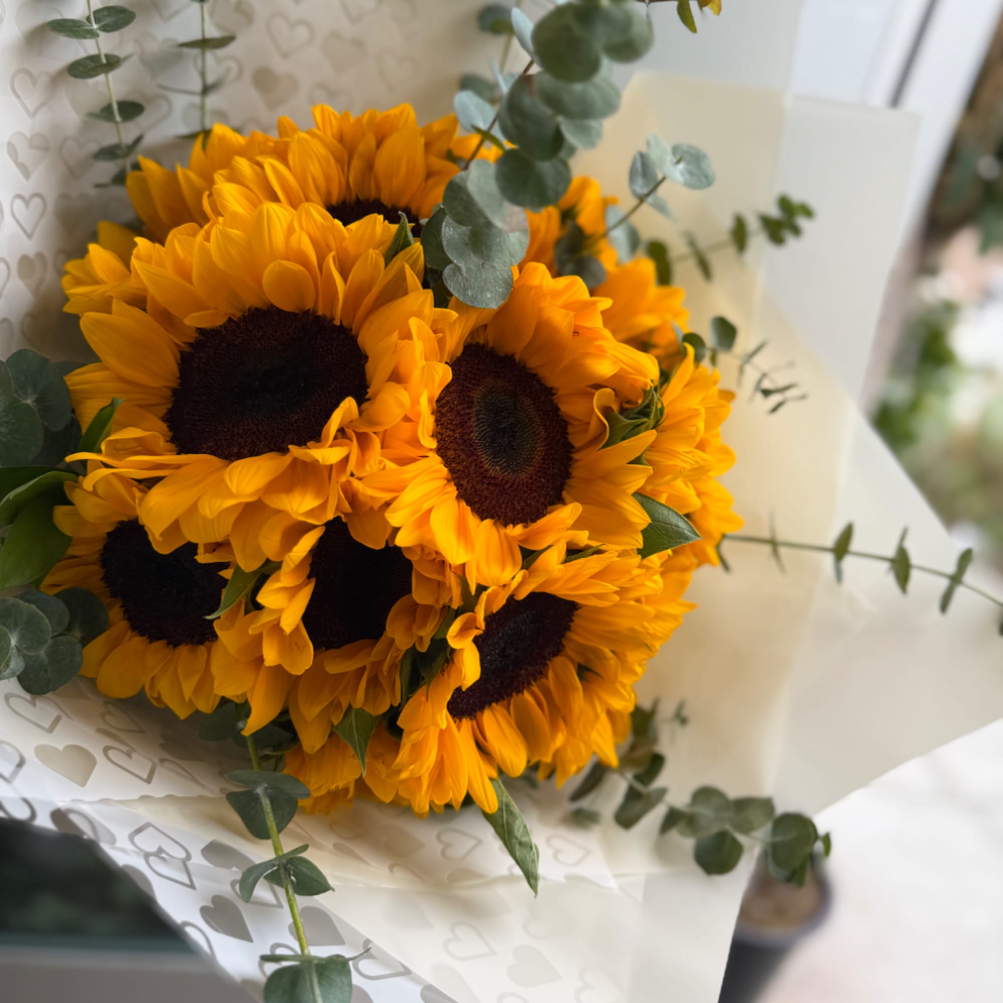 Bouquet of bright sunflowers wrapped in white paper