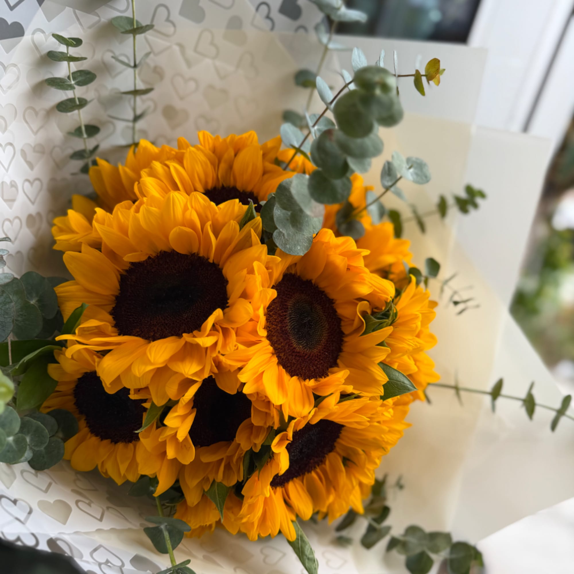 Bouquet of sunflowers with eucalyptus in white wrapping
