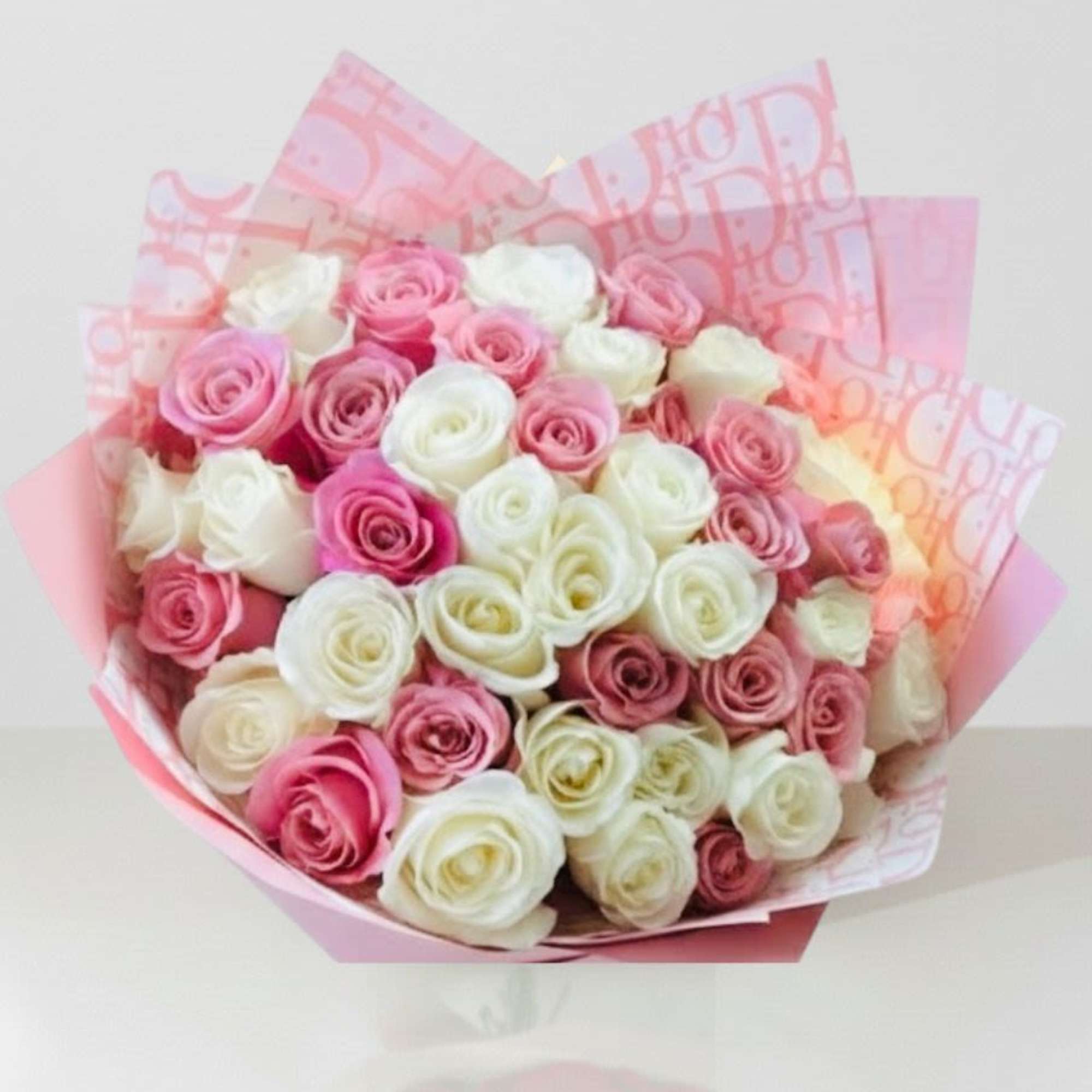 Bouquet of pink and white roses wrapped in pink paper