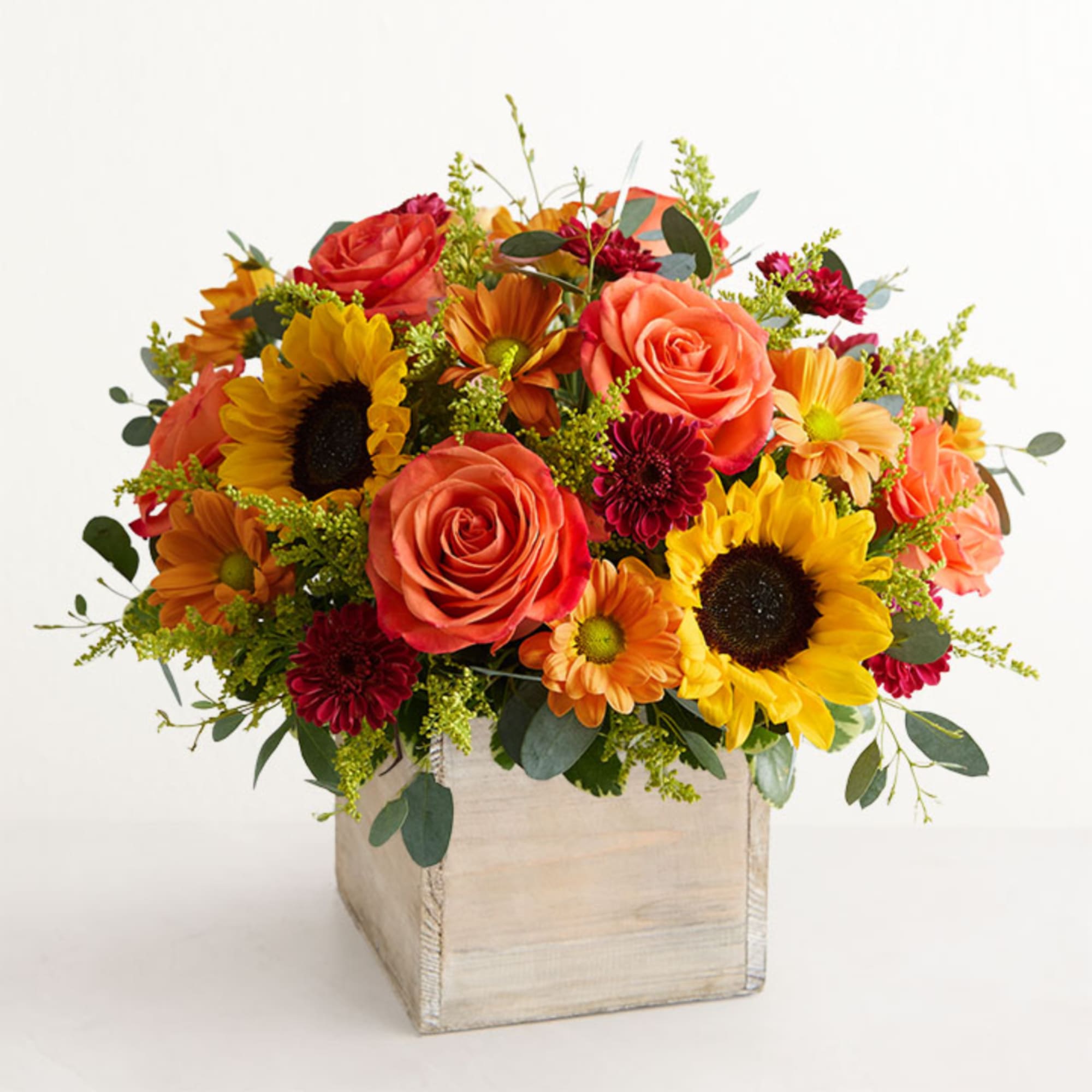 Mixed bouquet of roses and sunflowers in a square wooden box