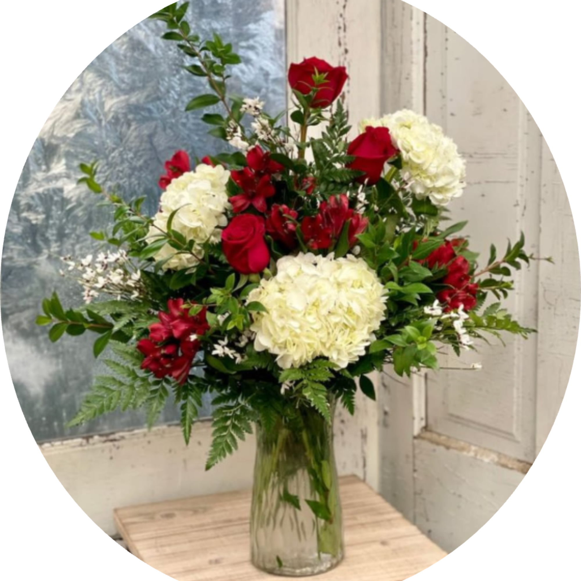 Rich red roses paired with creamy white hydrangeas give this flower arrangement
