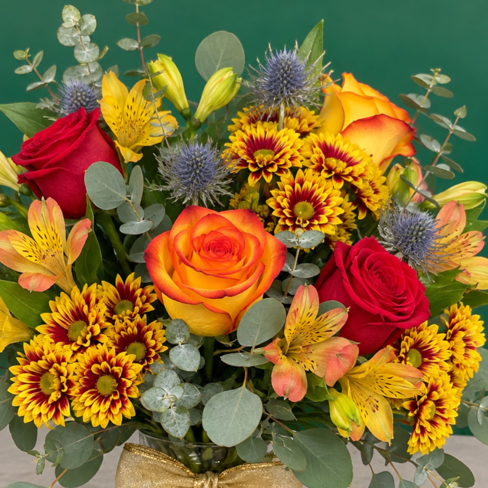 Bouquet of red and orange roses with yellow flowers in a glass vase