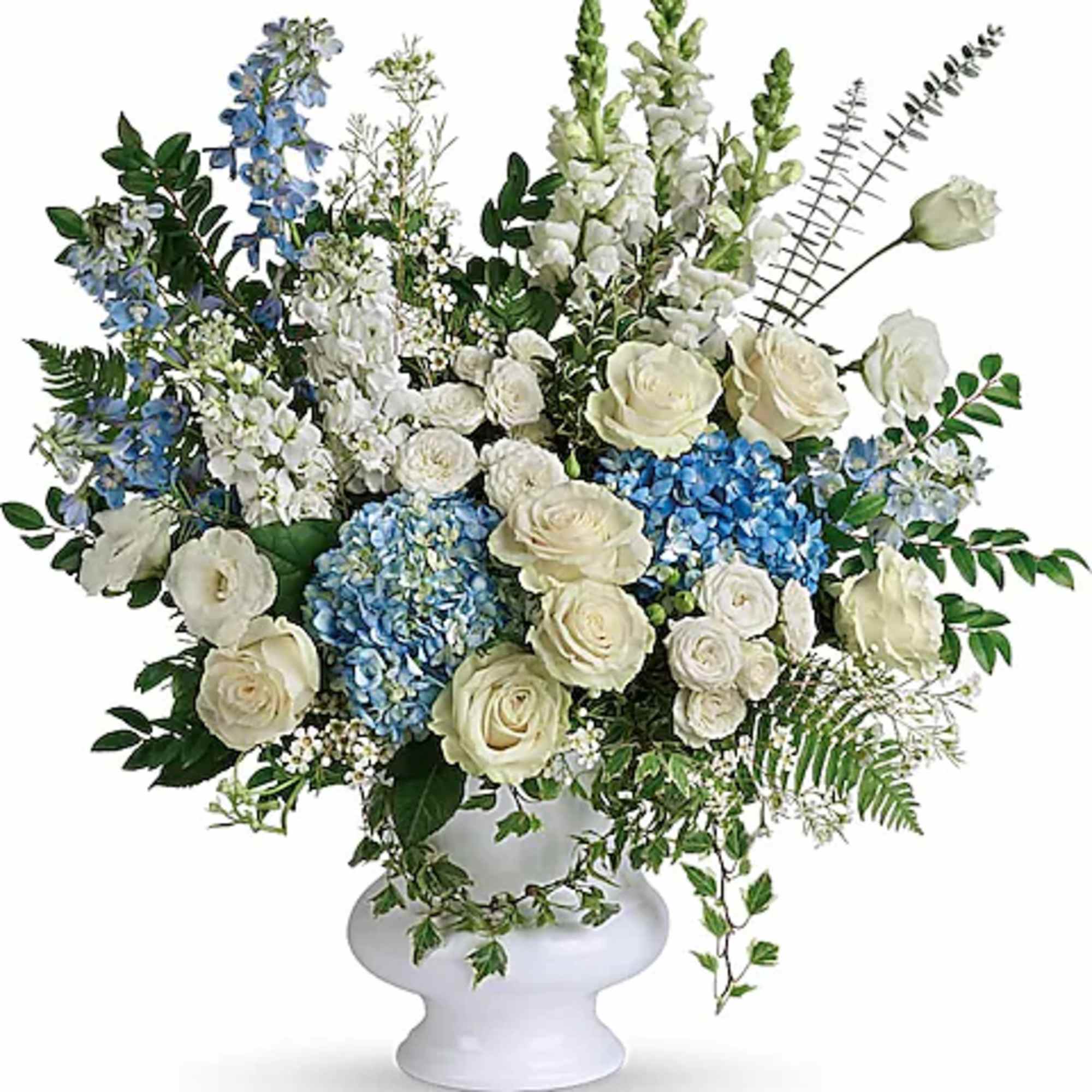 White and blue floral arrangement in a white pedestal vase