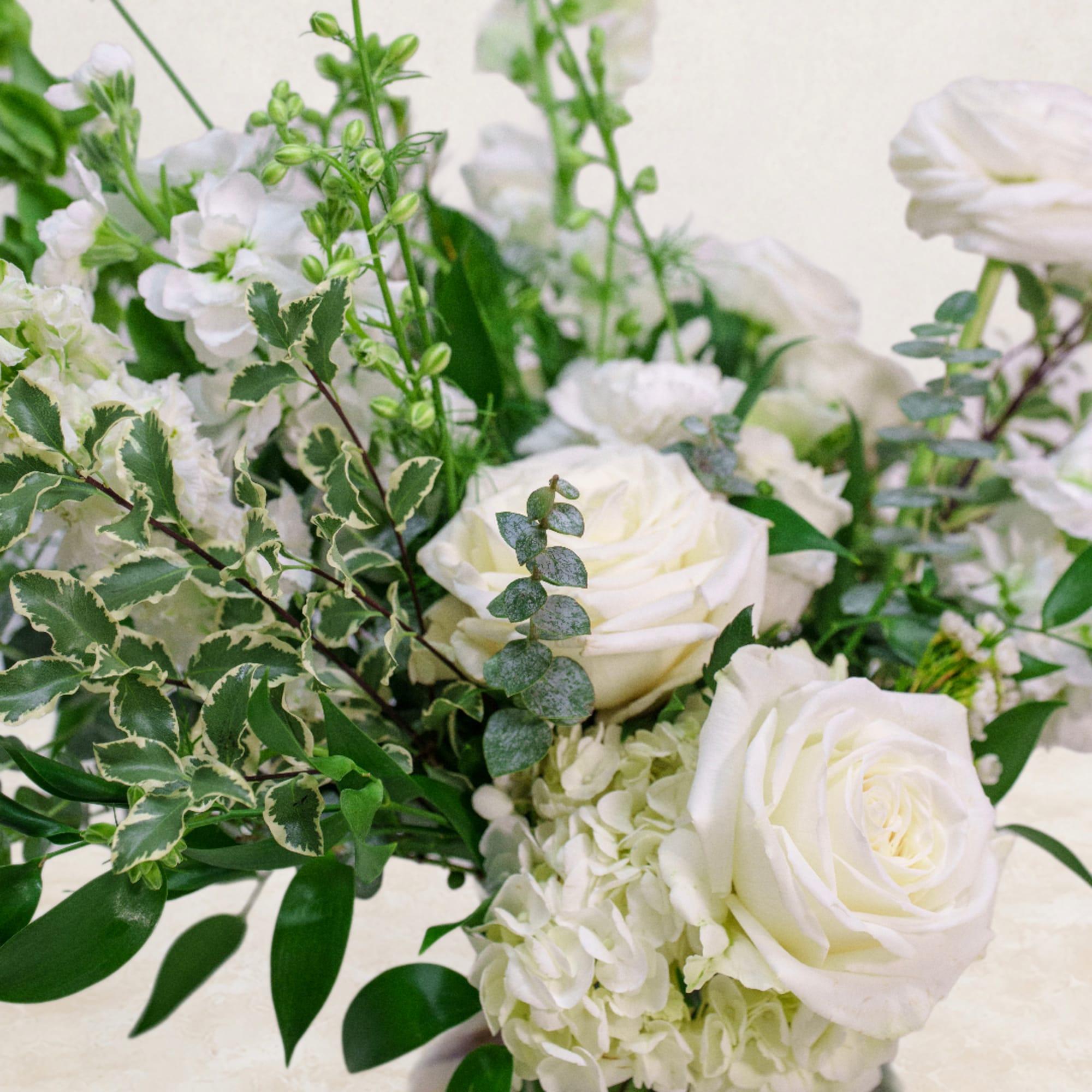 White roses and hydrangeas with mixed greenery in a bouquet