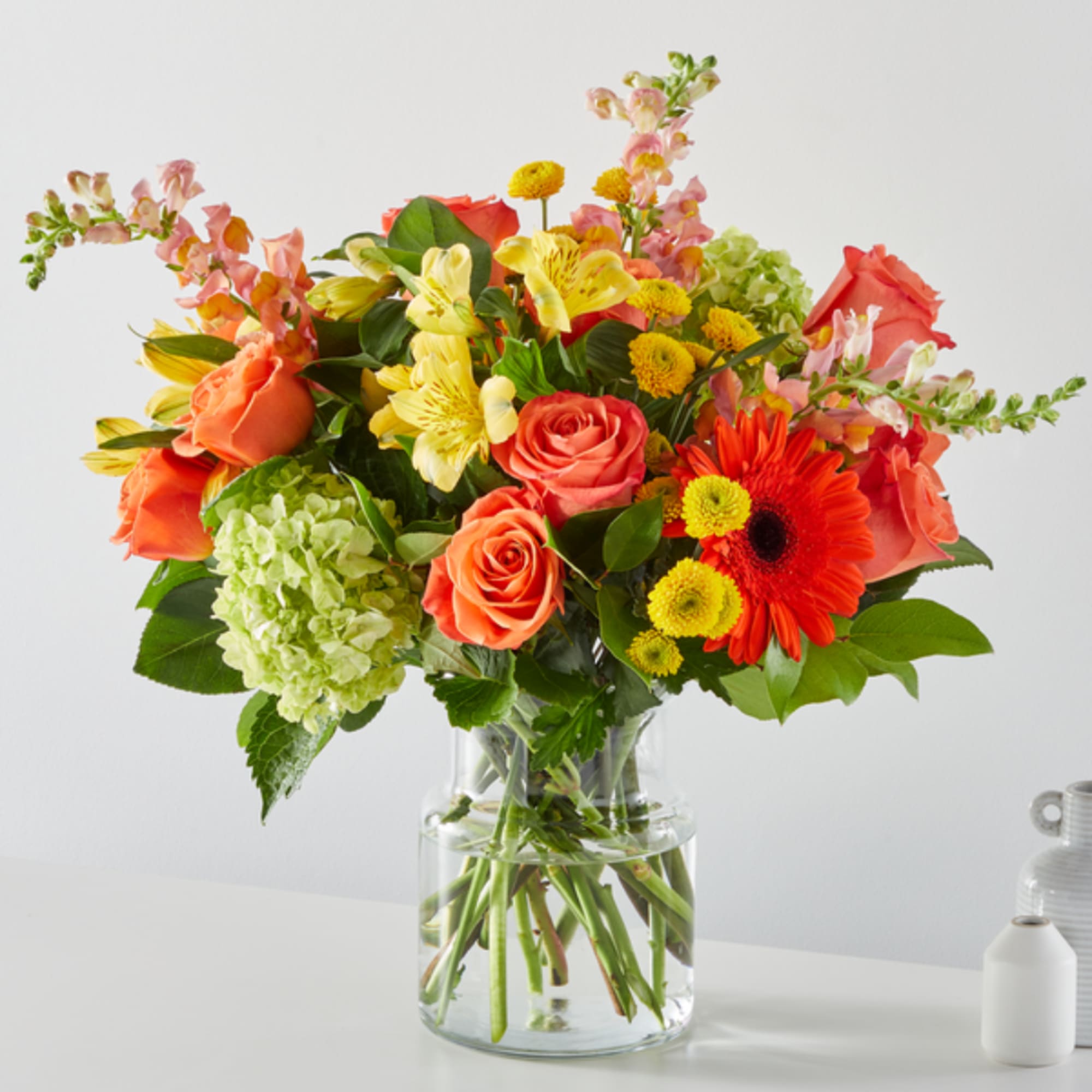 Mixed bouquet of roses, gerbera daisies, and alstroemeria in a glass vase