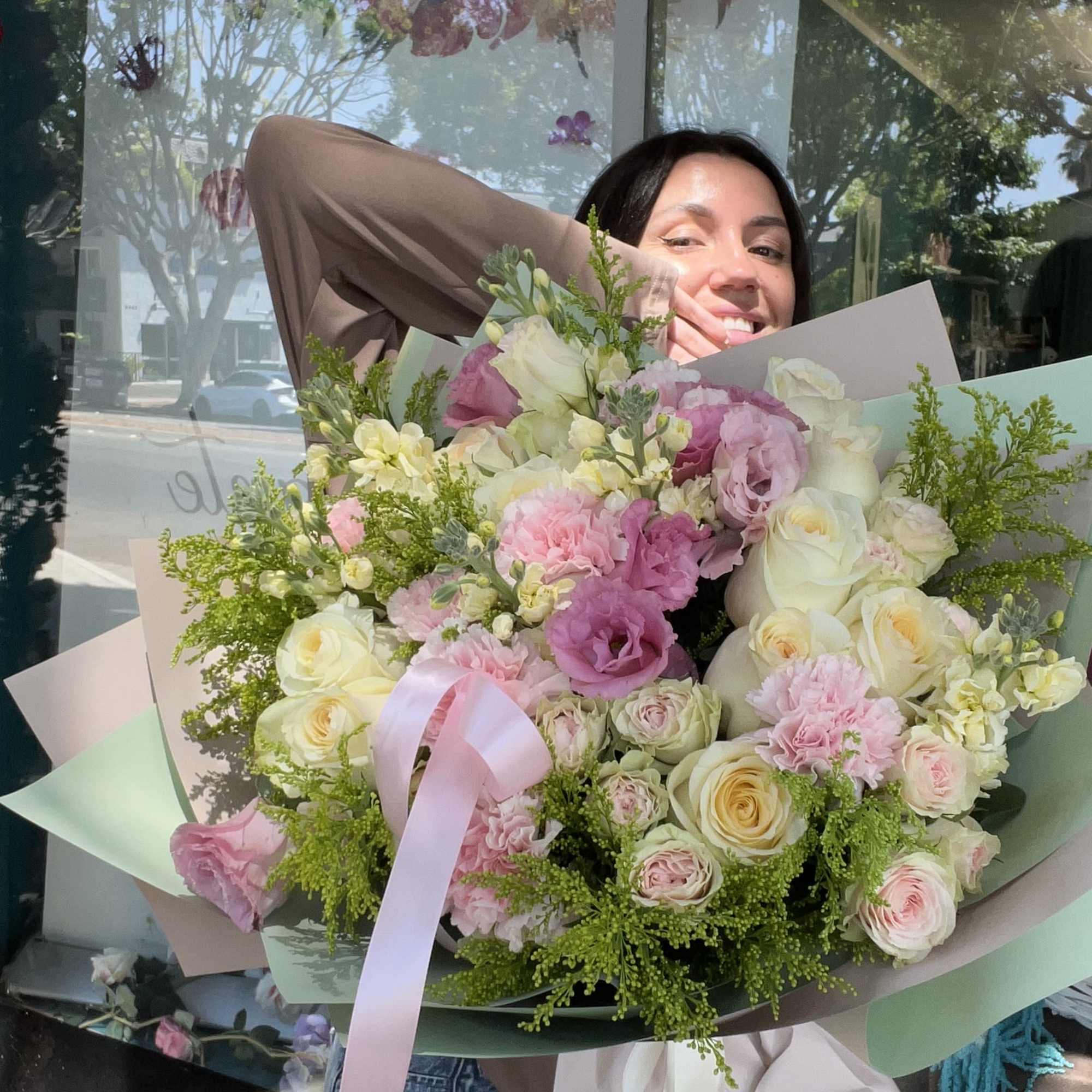 Large bouquet of pink and white roses with pastel wrapping and ribbon