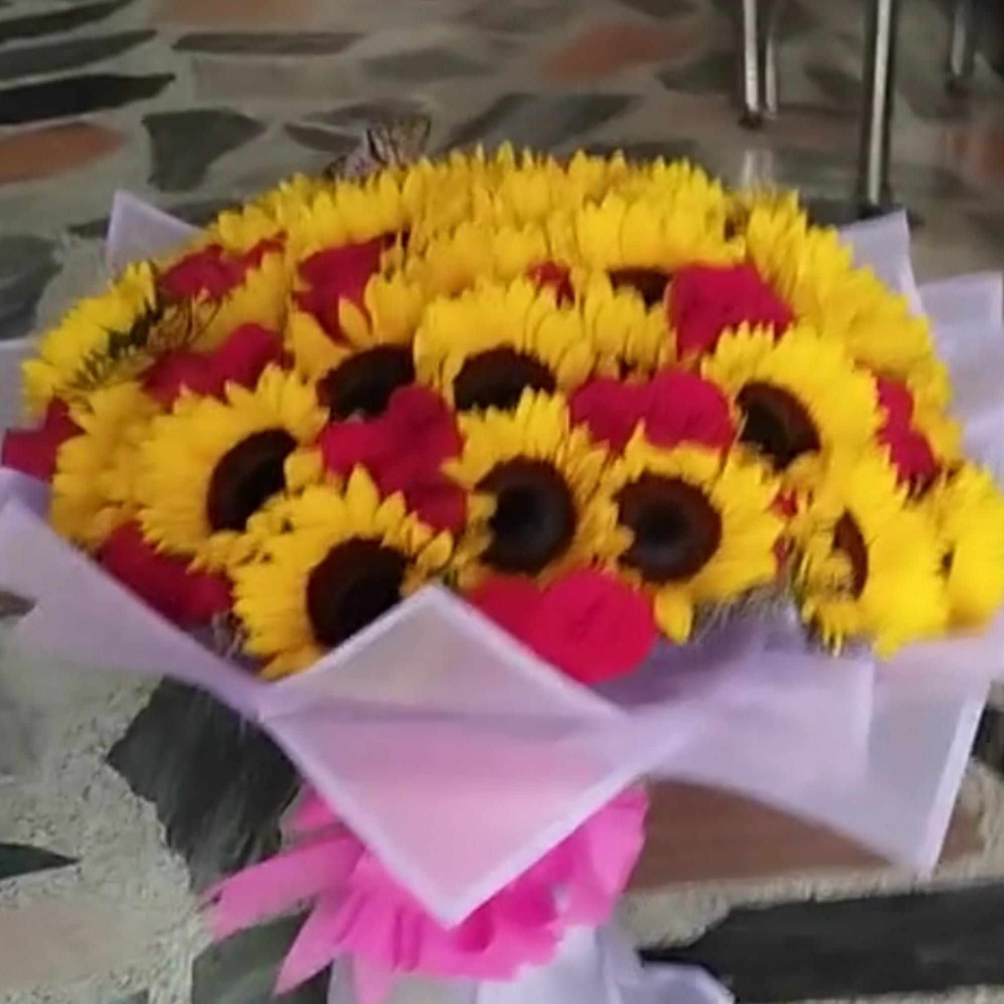 Bouquet of yellow sunflowers with pink flowers wrapped in white paper