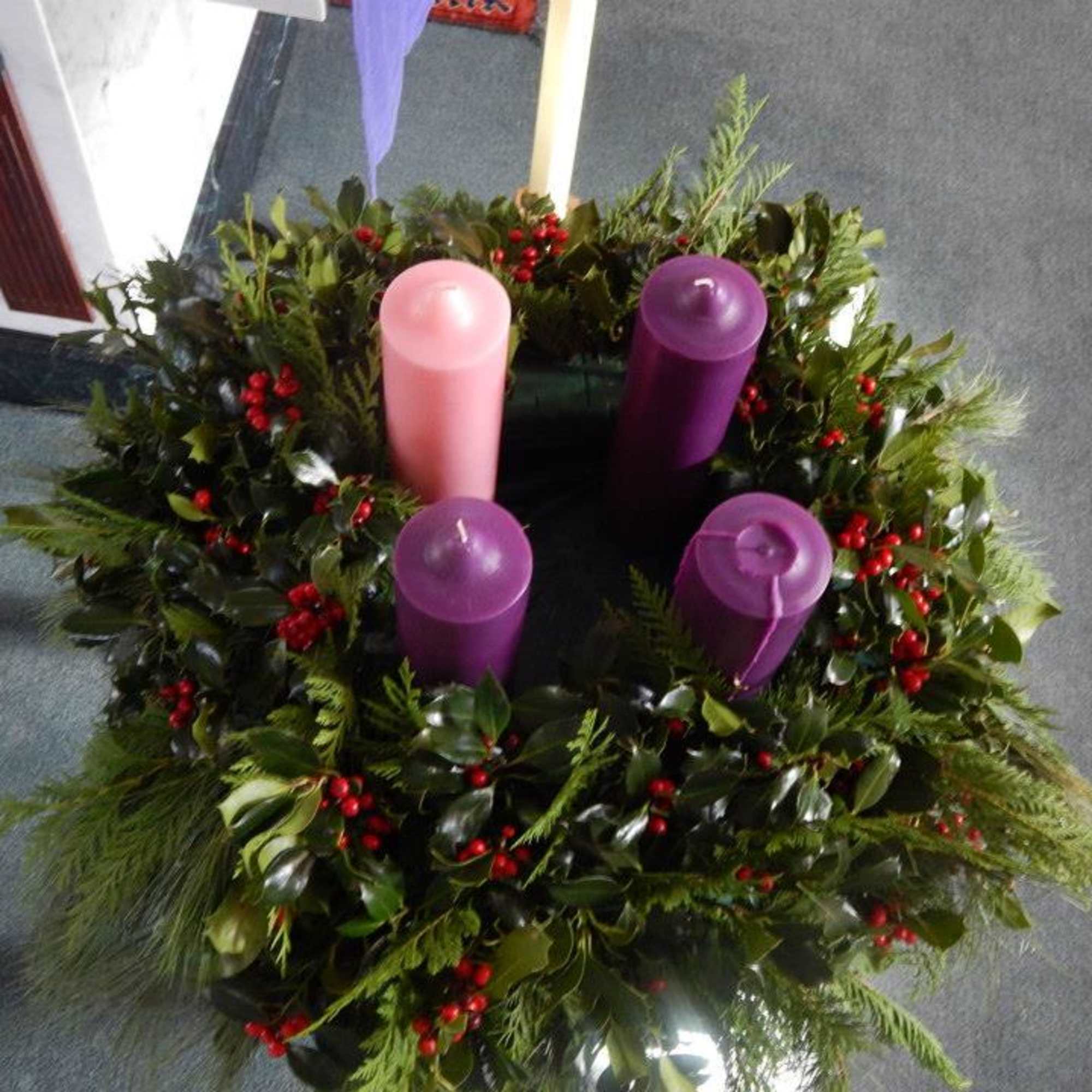 Holiday wreath with four purple and pink candles