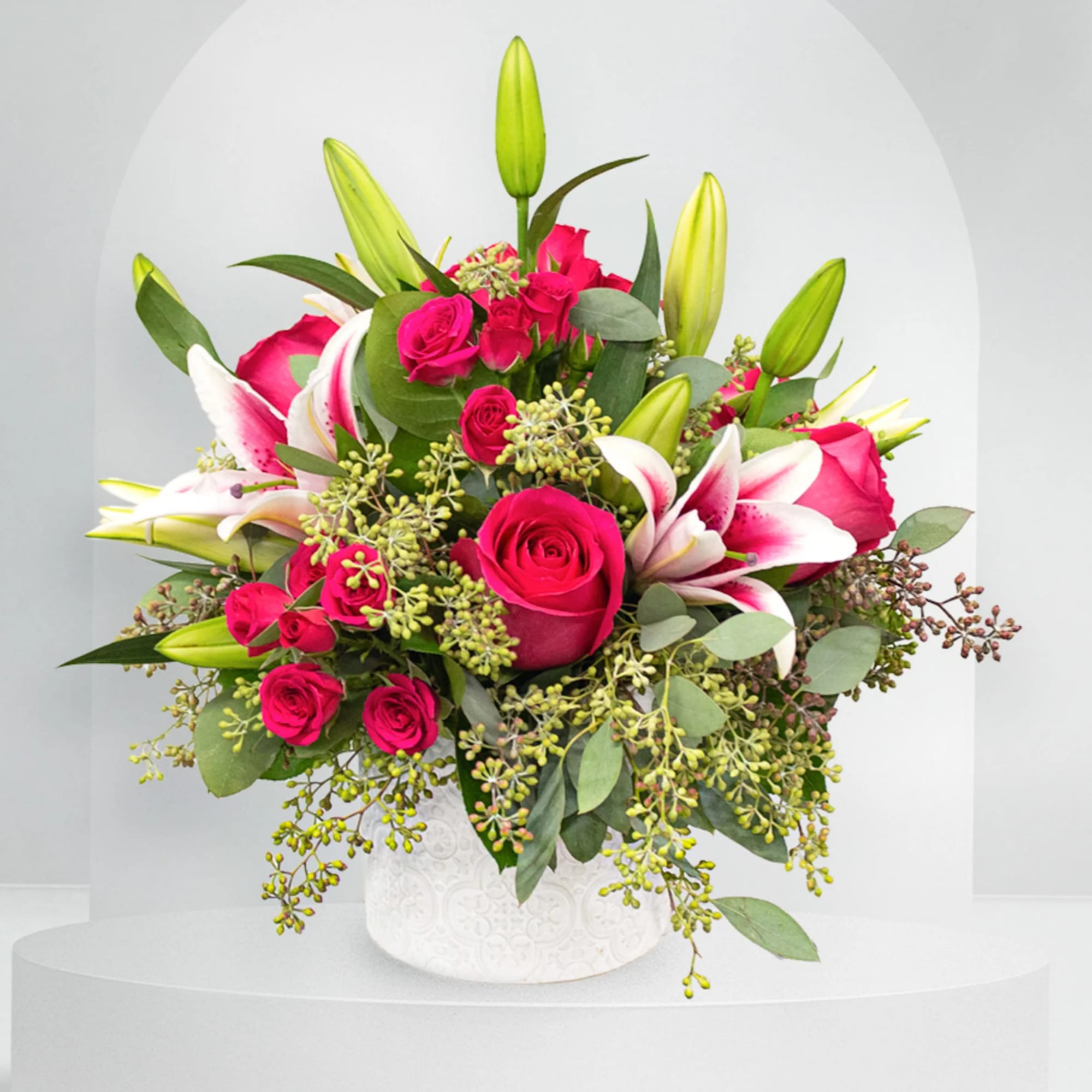 Pink roses and white lilies in a white vase