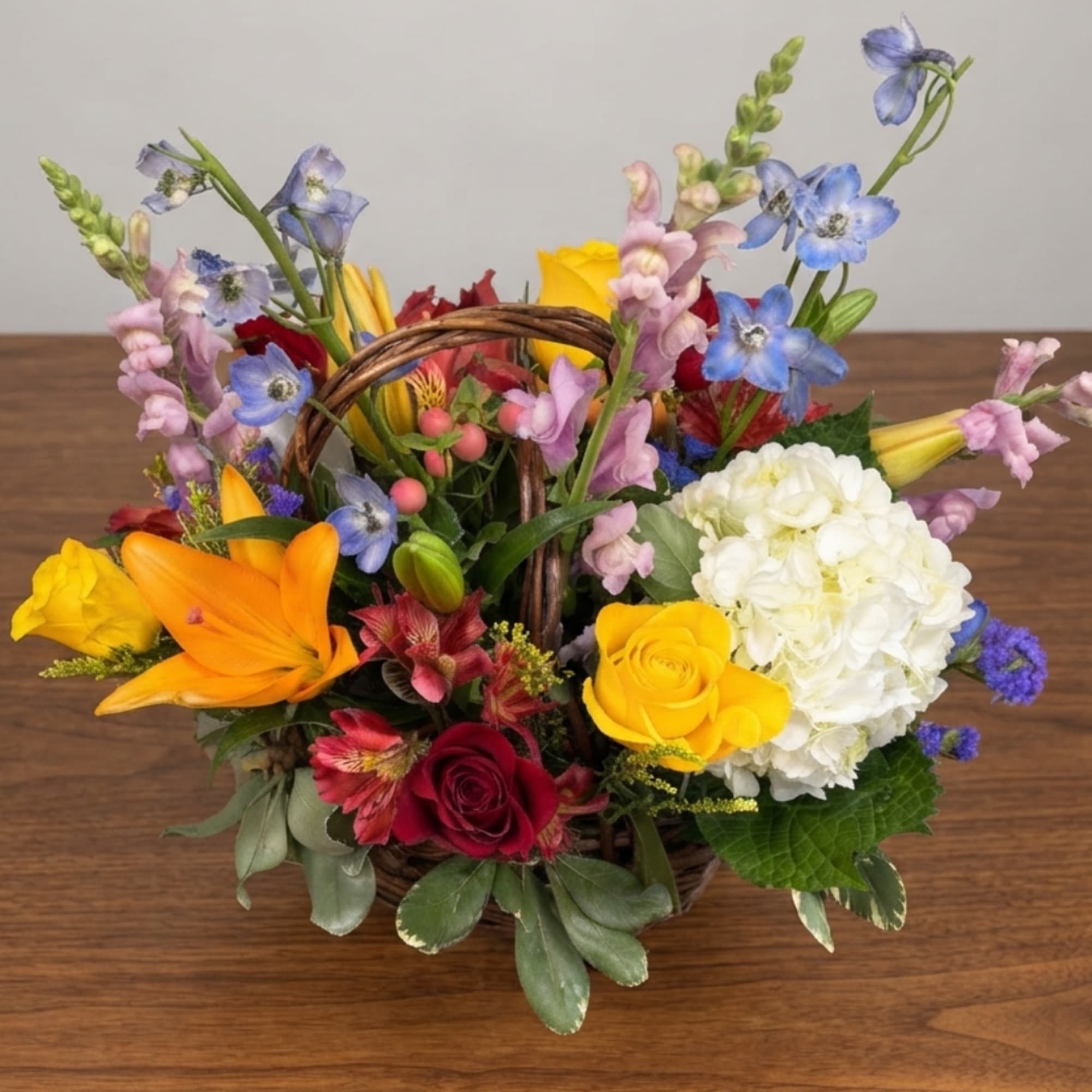 Colorful flower basket with roses, hydrangea, lilies, and snapdragons