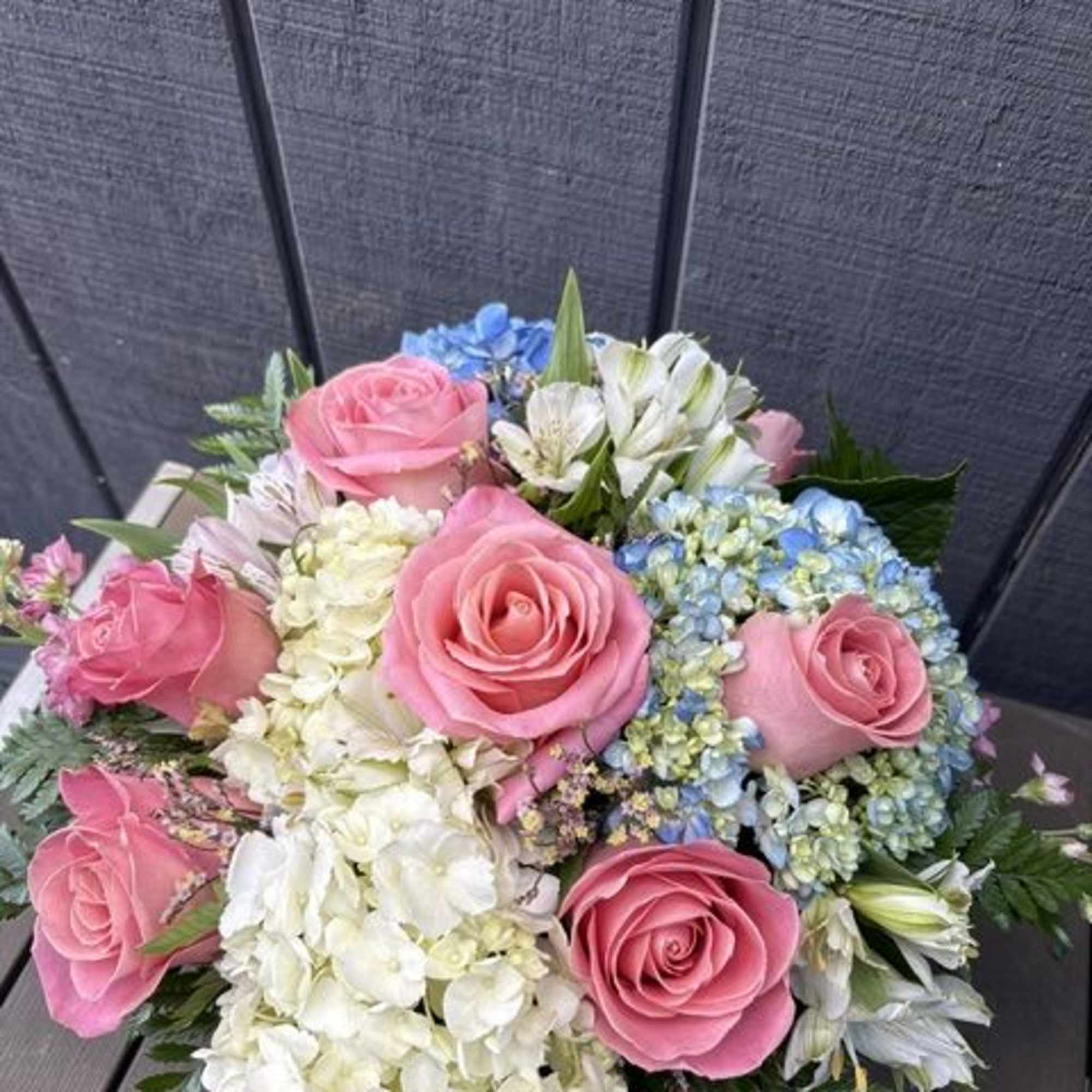 Soft, cheerful, and romantic, this mixed bouquet of pink, white, and blue
