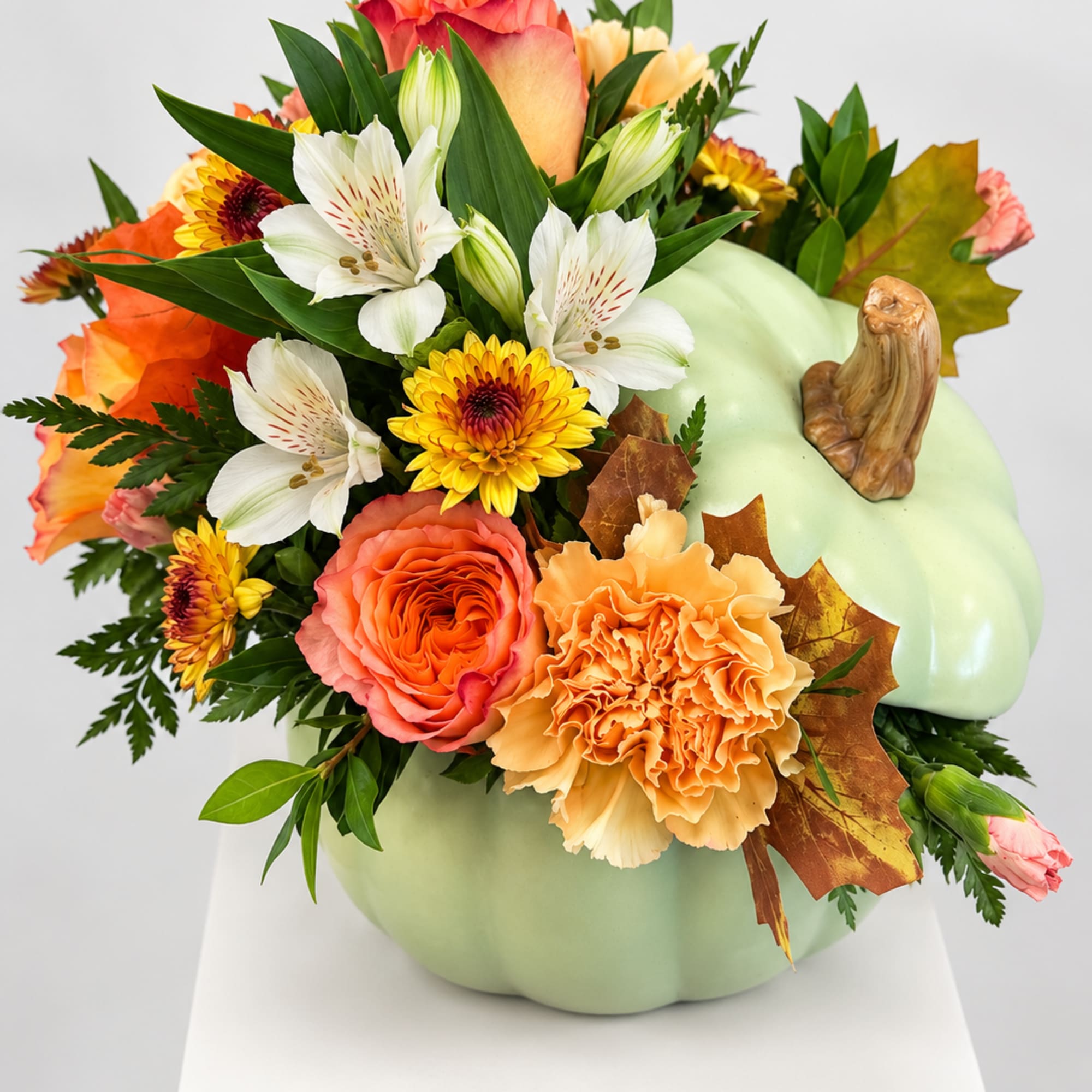 Pumpkin-shaped floral arrangement with orange, white, and yellow blooms