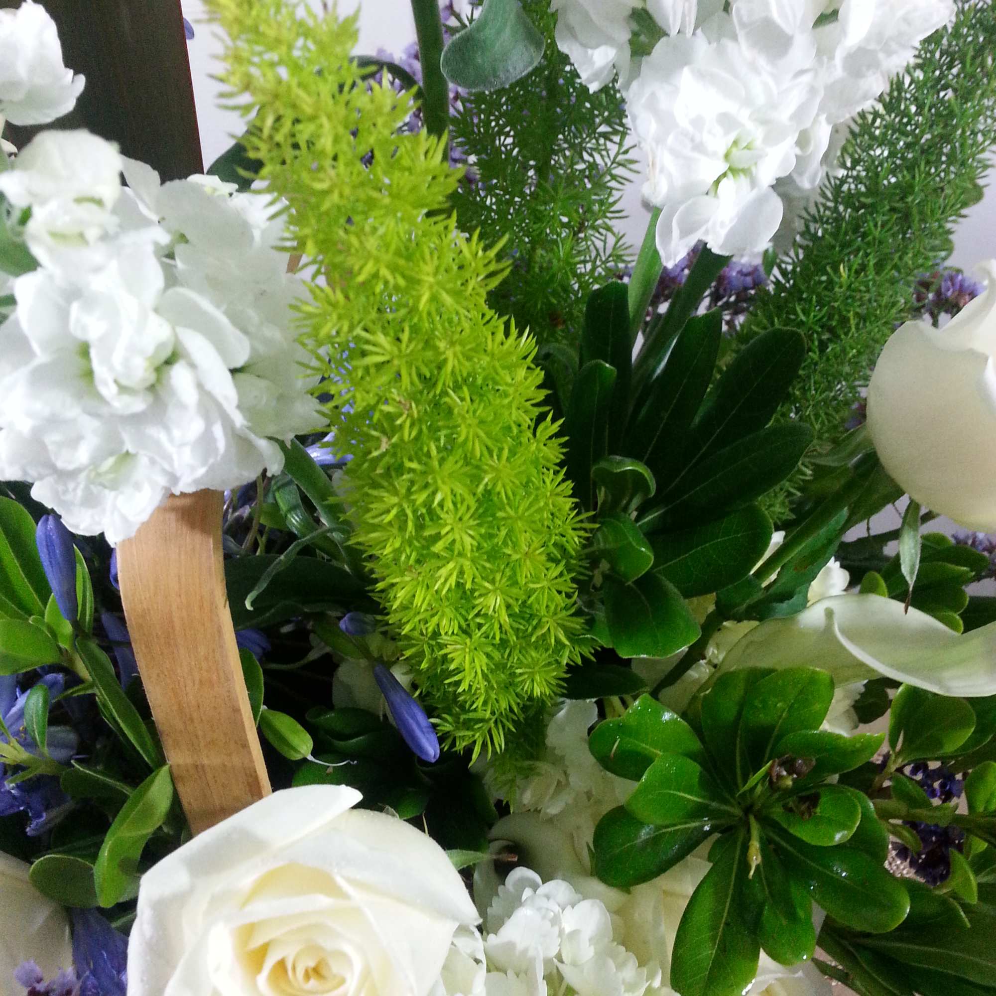 White roses and white blooms with bright green filler in a mixed bouquet