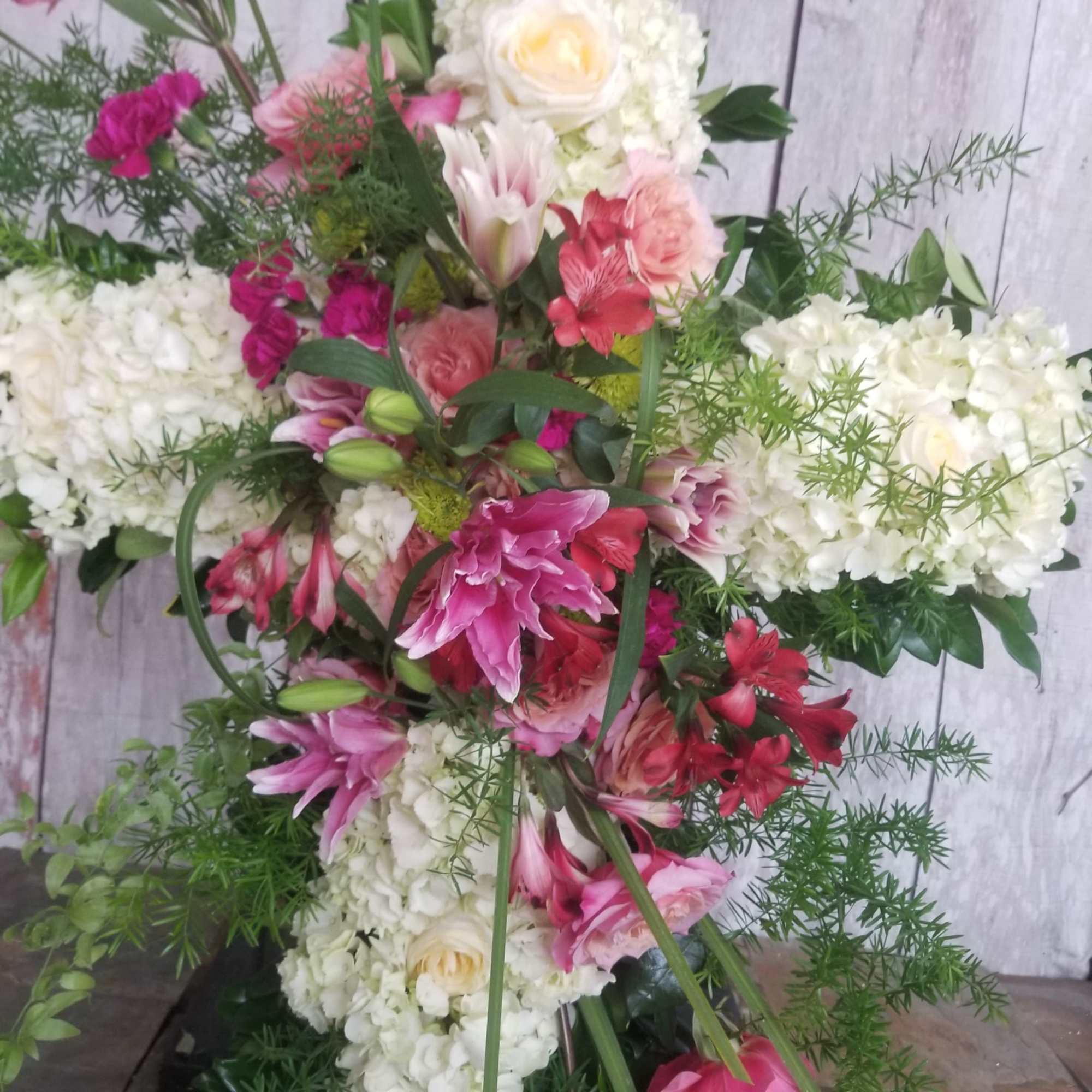 Tall floral arrangement with pink and white blooms and greenery