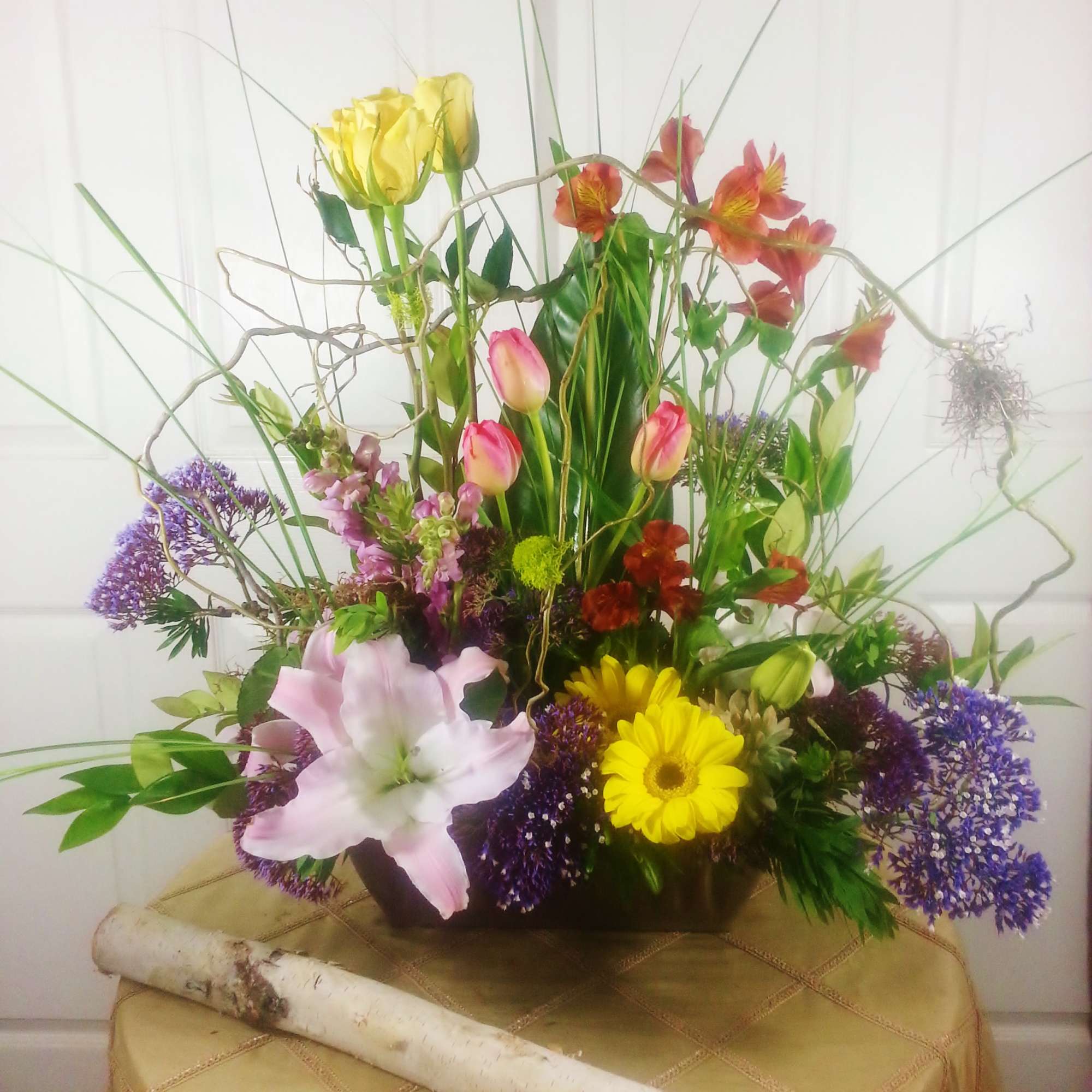 Tall mixed bouquet with lilies, tulips, daisies, and purple filler flowers