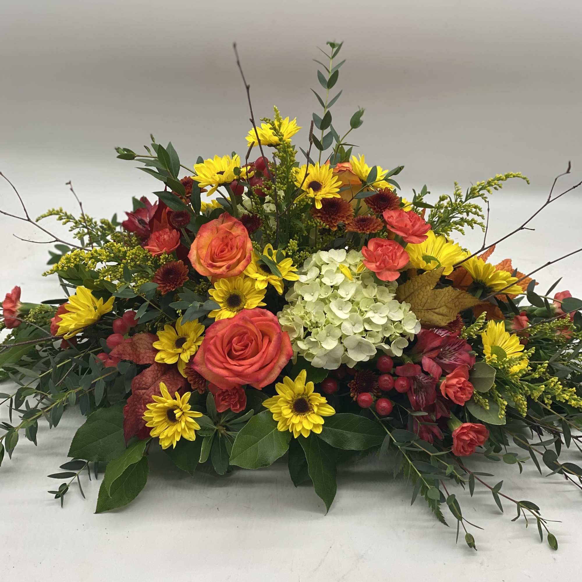 A beautiful mix of fall blooms designed long and low. 
