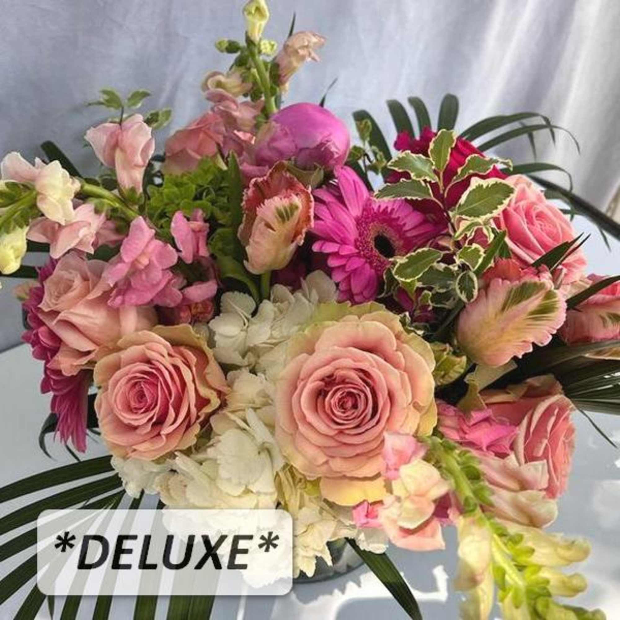 Deluxe pink and peach rose arrangement with hydrangeas, gerbera daisies, and snapdragons in a clear glass vase