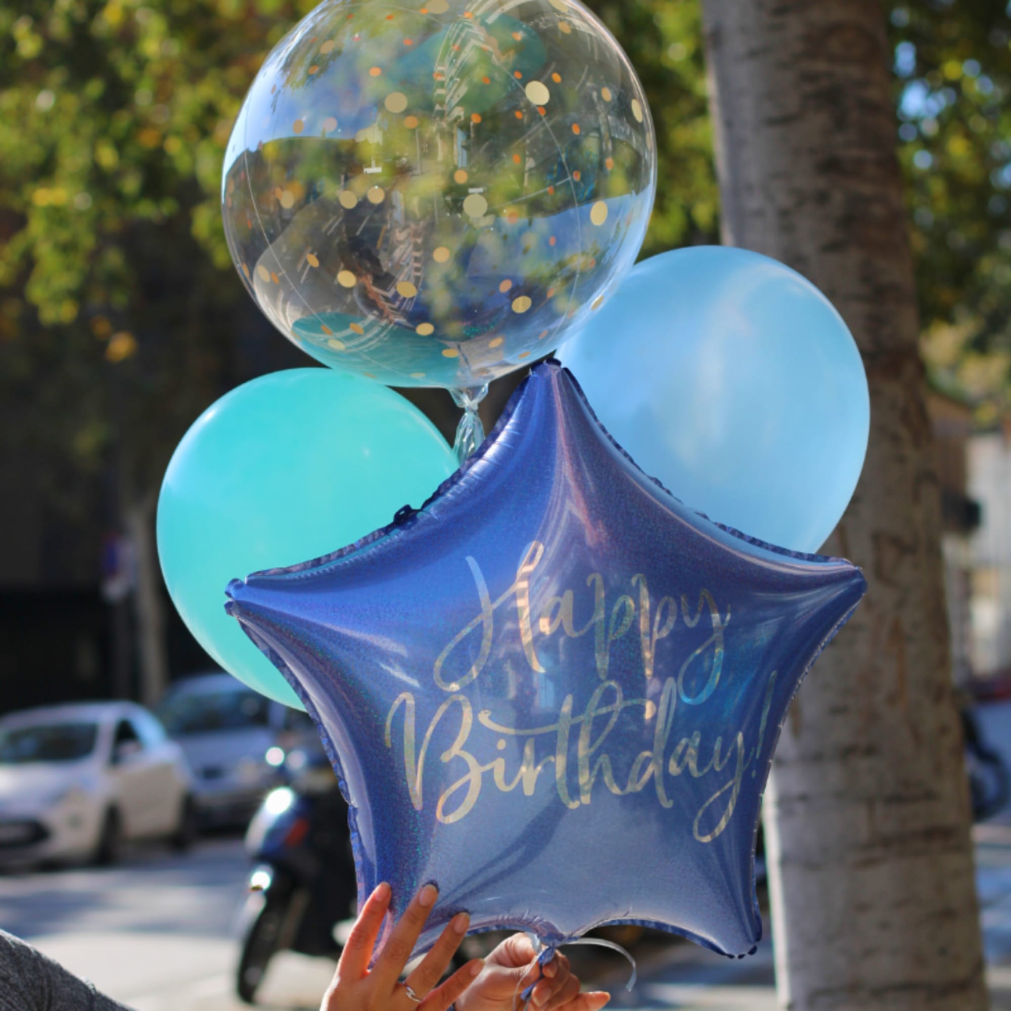 Birthday balloon bouquet with a blue star balloon and pastel balloons
