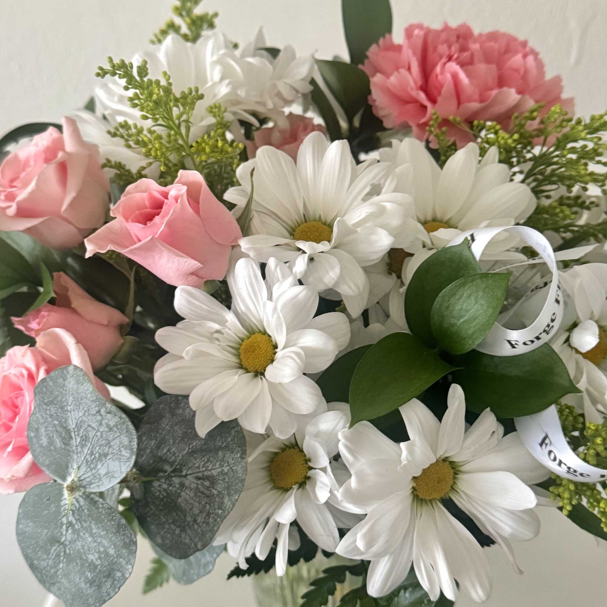 A charming arrangement of fresh white daisies and soft blush blooms, accented, photo 2 of 3