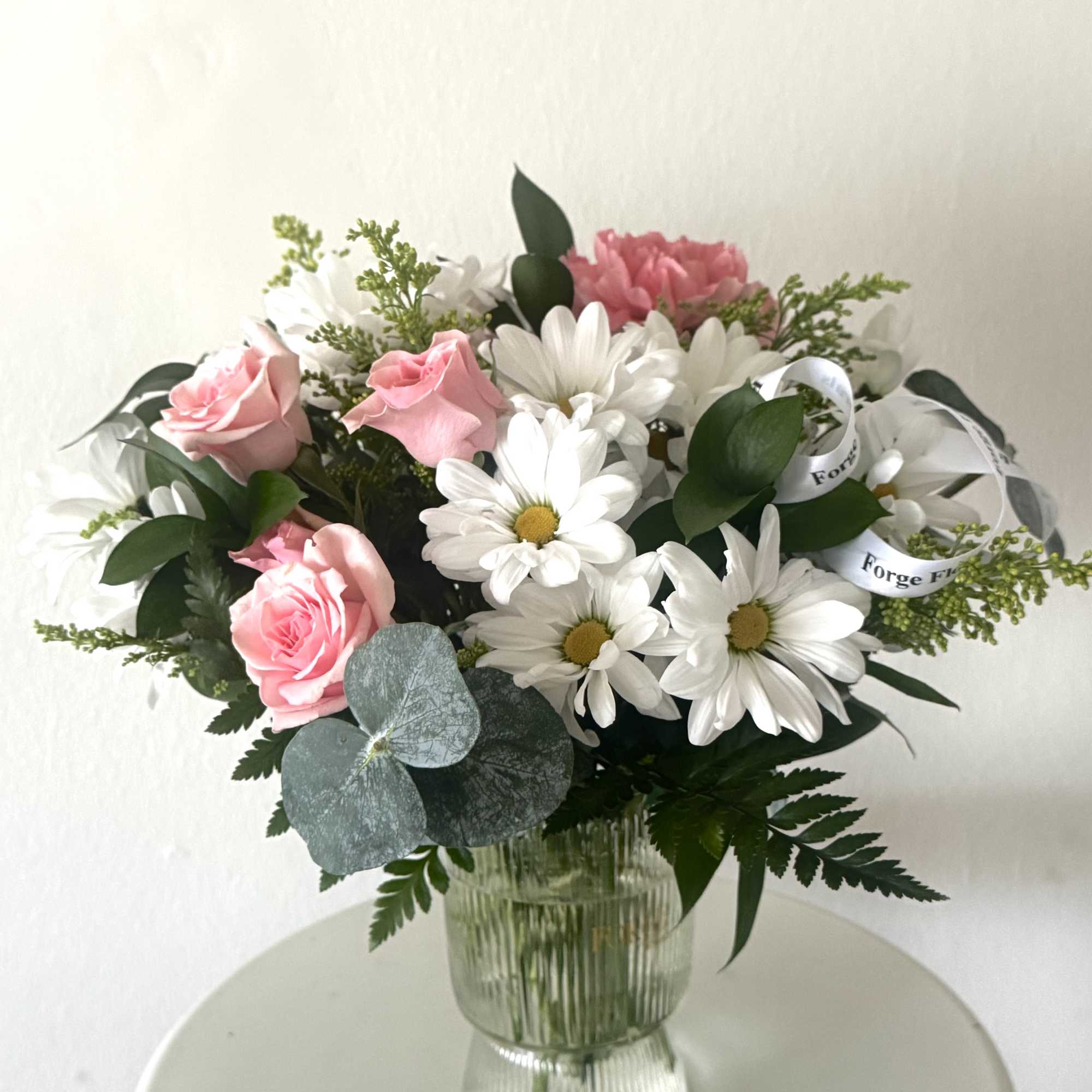 A charming arrangement of fresh white daisies and soft blush blooms, accented, photo 3 of 3