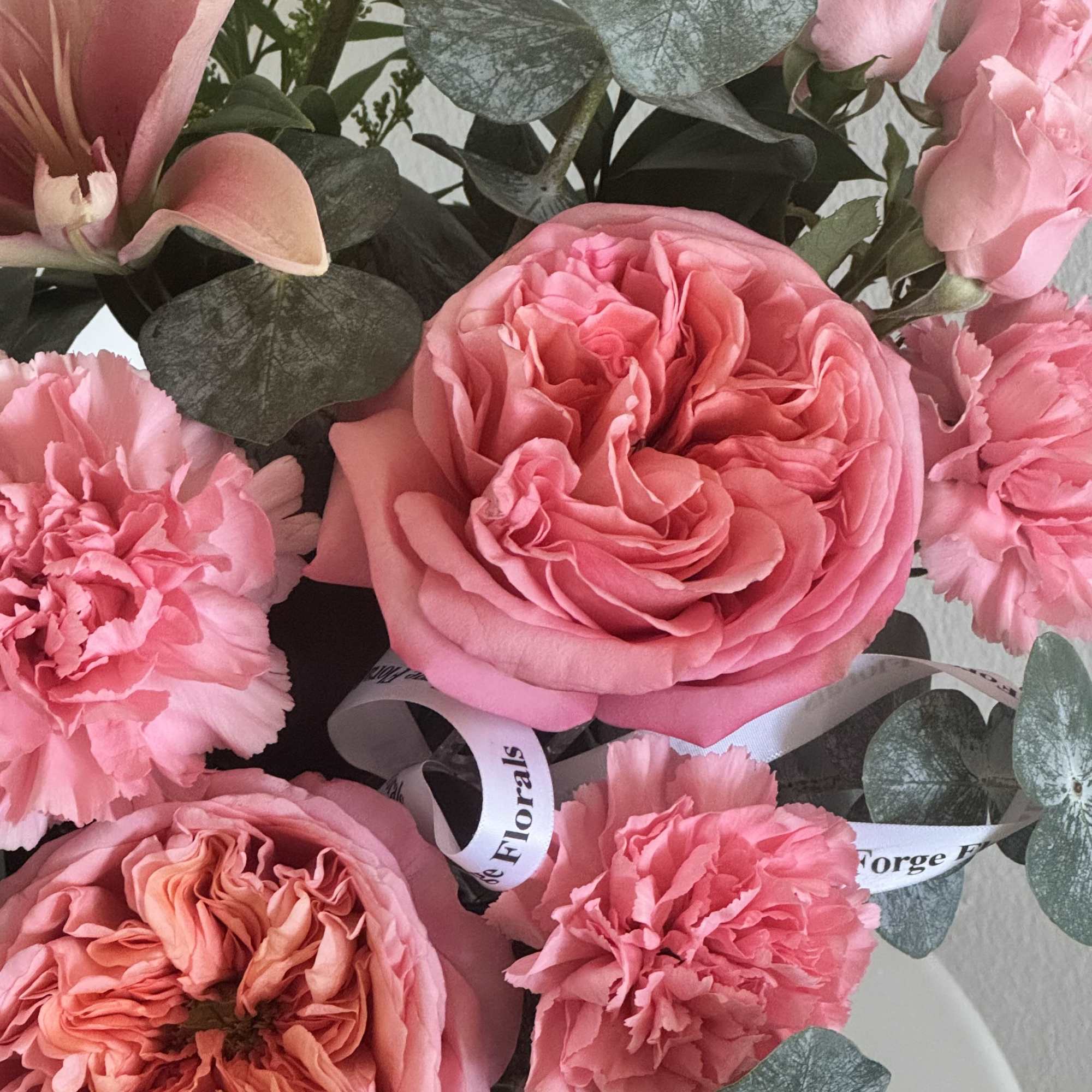 A lush garden-style arrangement featuring soft pink roses, spray roses, carnations and, photo 2 of 2