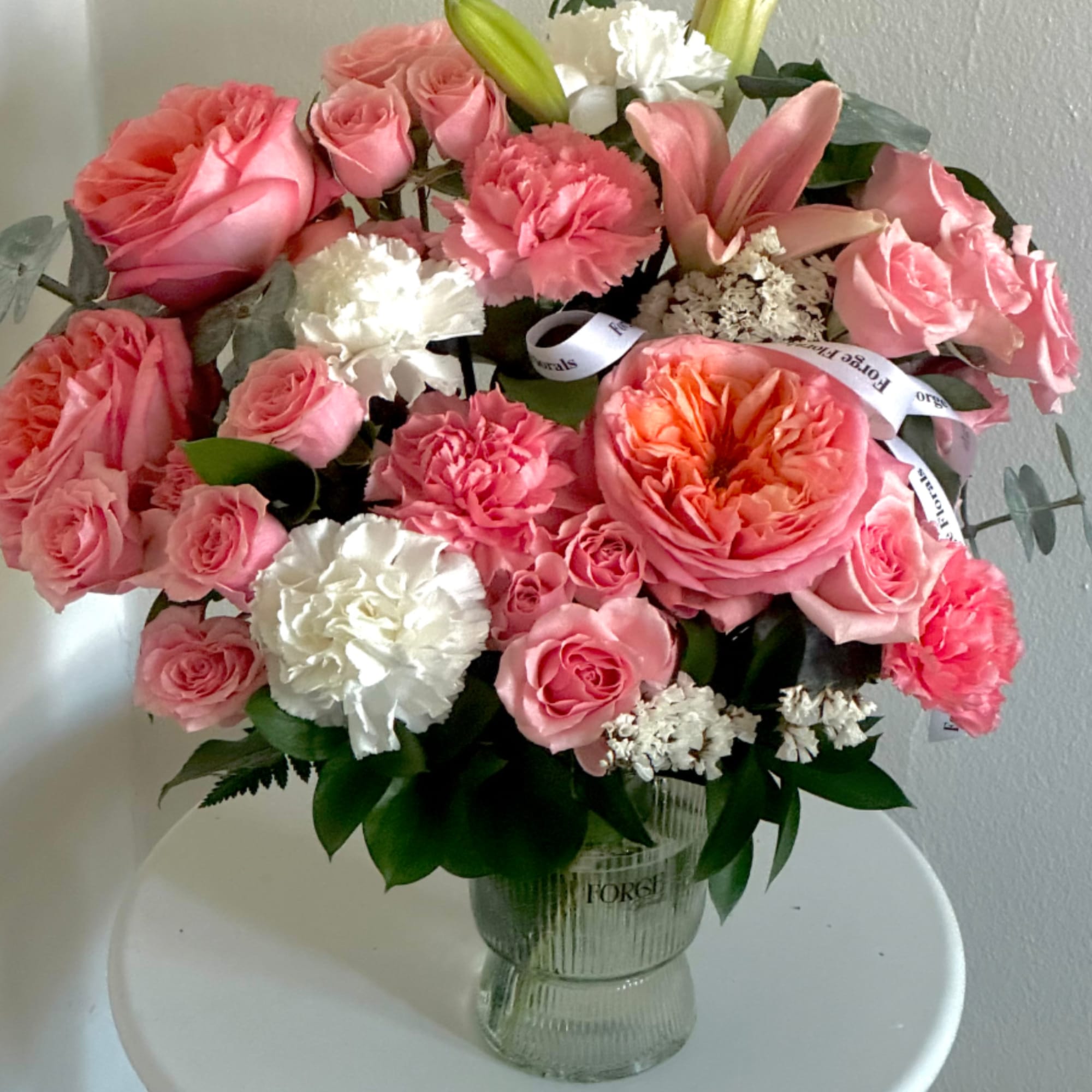 Vase arrangement with pink garden roses and Lilly. Vase is made out