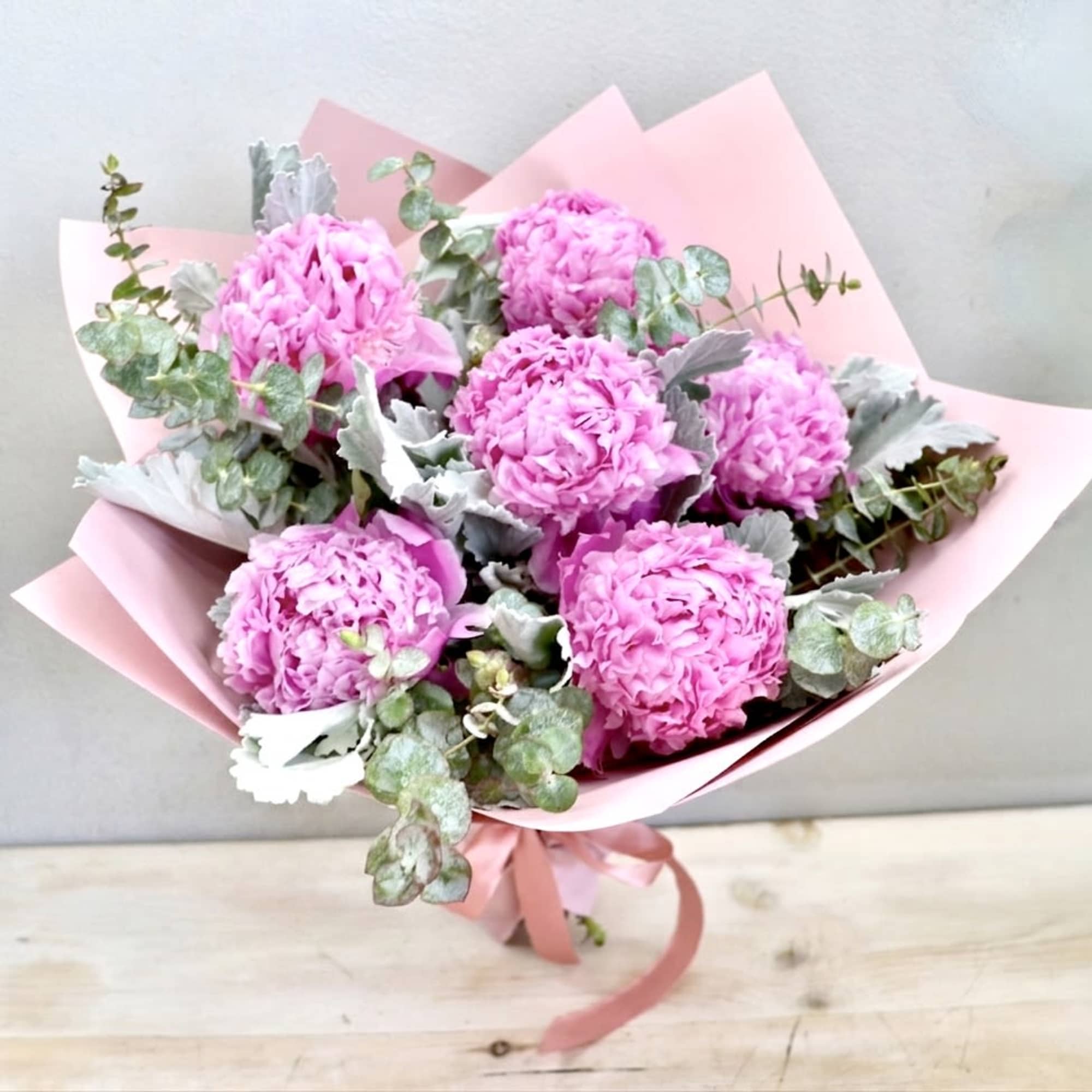 The standard size holds 6 peonies with seasonal greenery. The photo shown