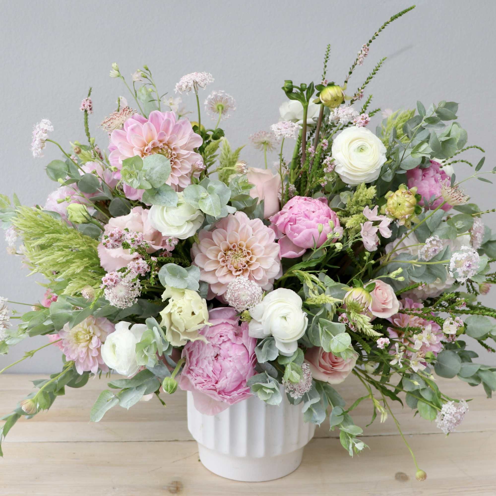 Pink and white mixed flower arrangement in a white vase