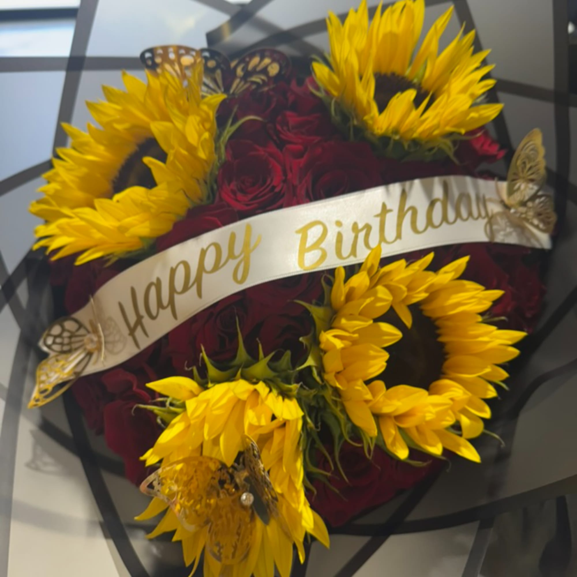 Bouquet of red roses and yellow sunflowers with a Happy Birthday ribbon