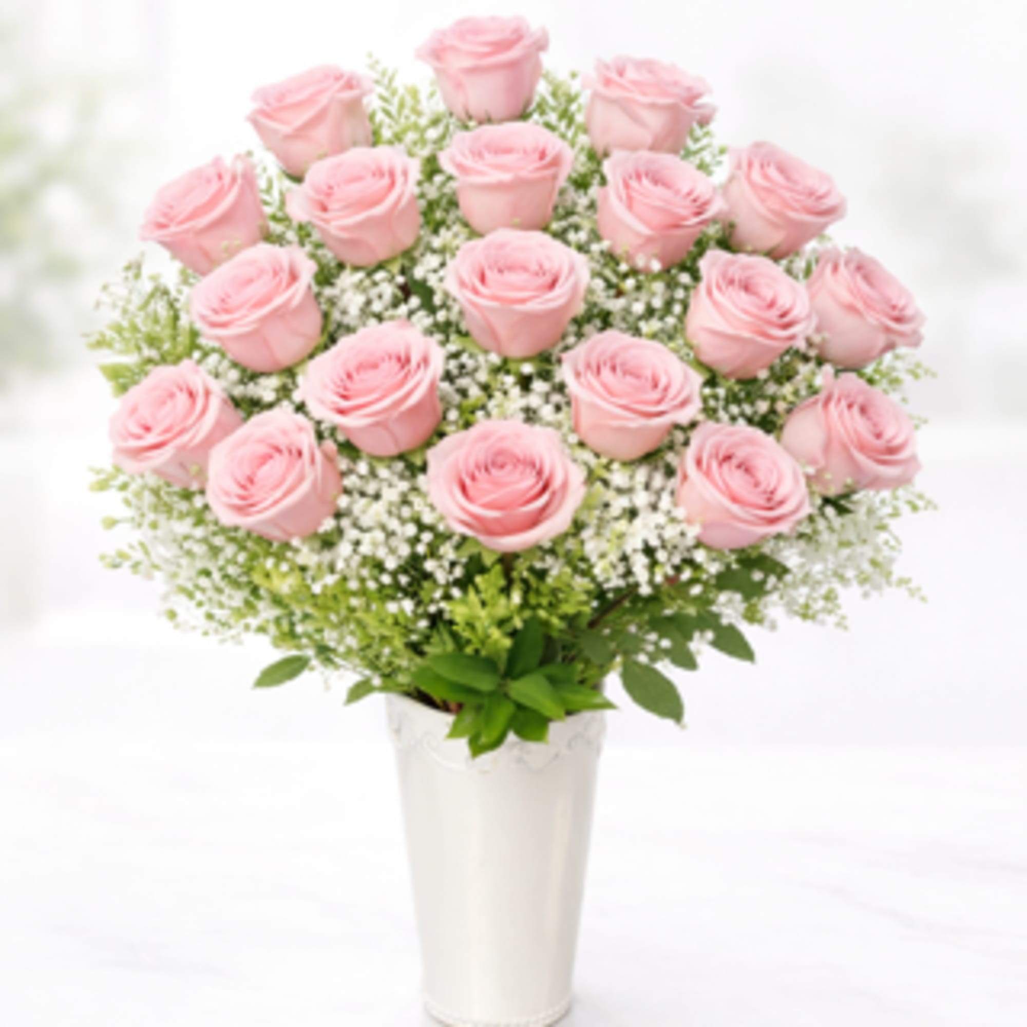 Rounded cluster of  pink roses with white filler and soft green