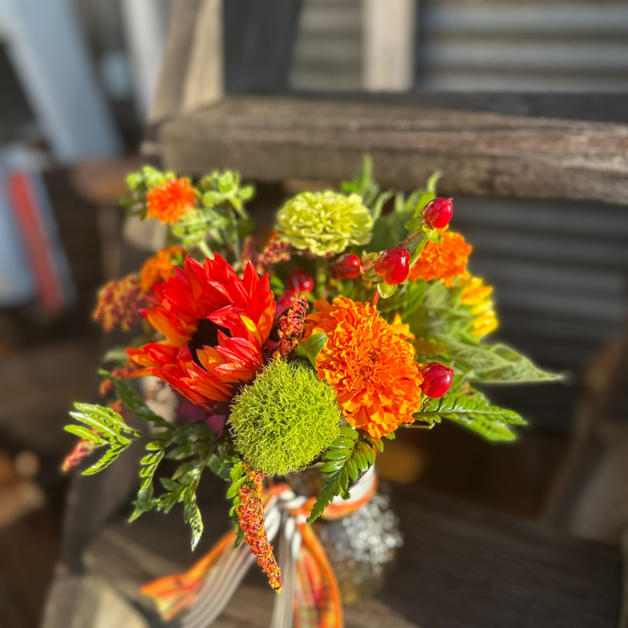 Bright mixed bouquet with orange and red flowers in a ribbon-tied wrap