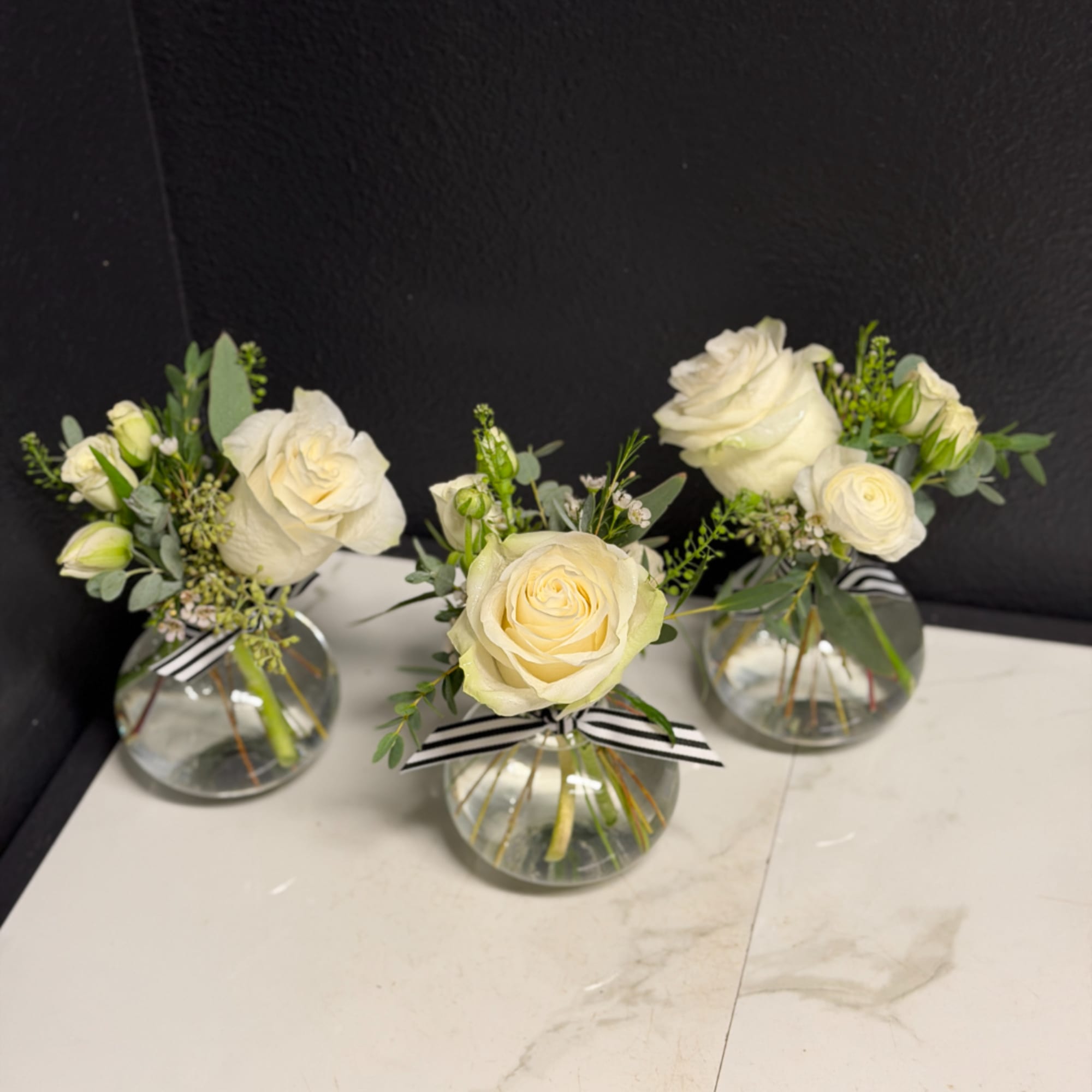 Three small white rose arrangements in round glass vases with striped ribbons, photo 4 of 4