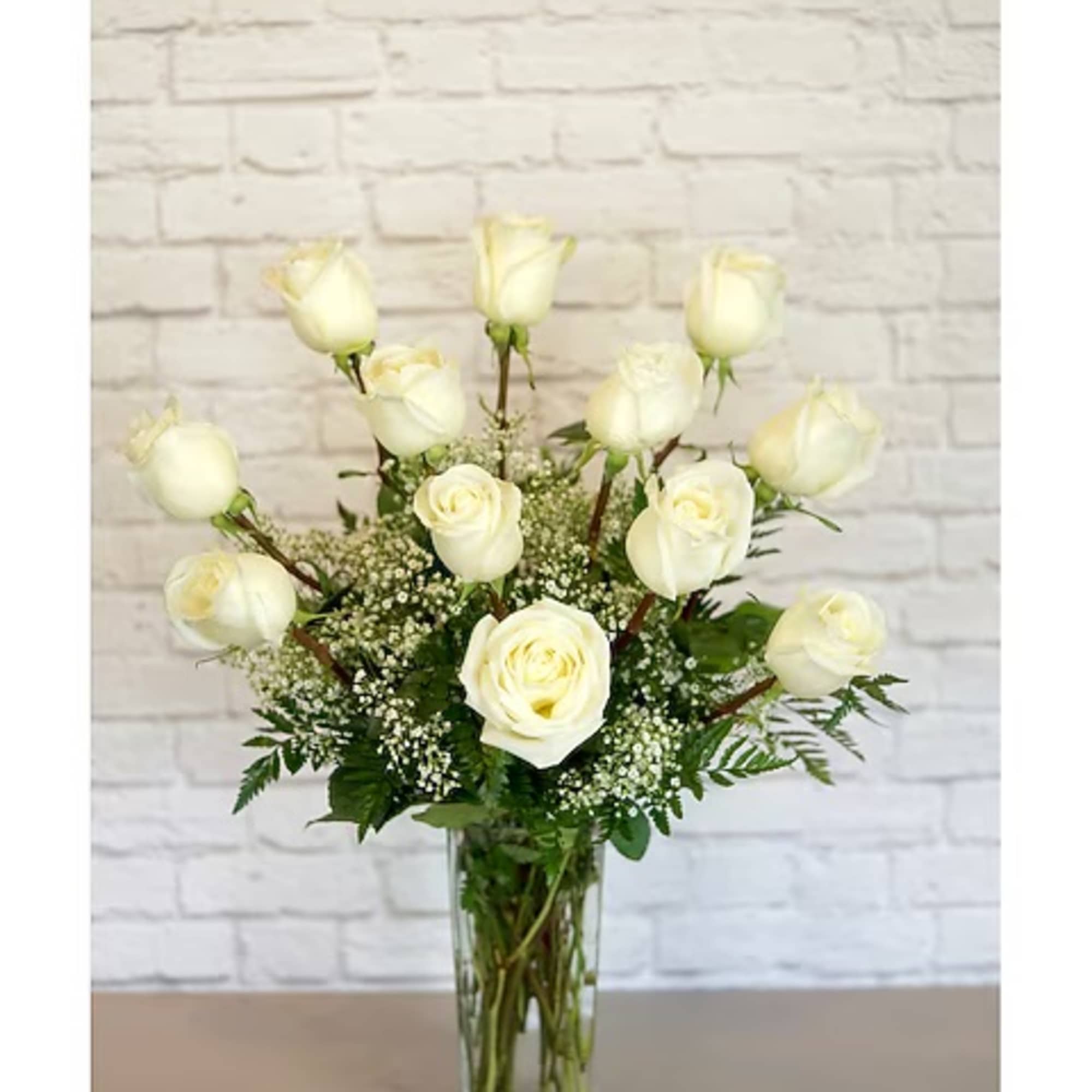 White roses arranged in a clear glass vase