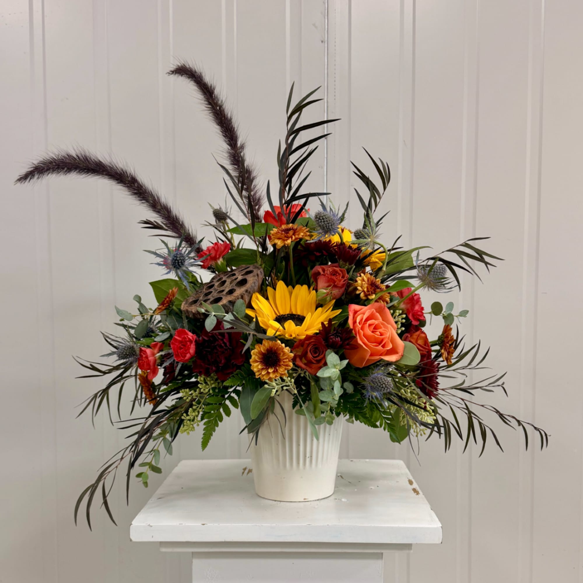 Mixed bouquet in a white vase with sunflowers and roses