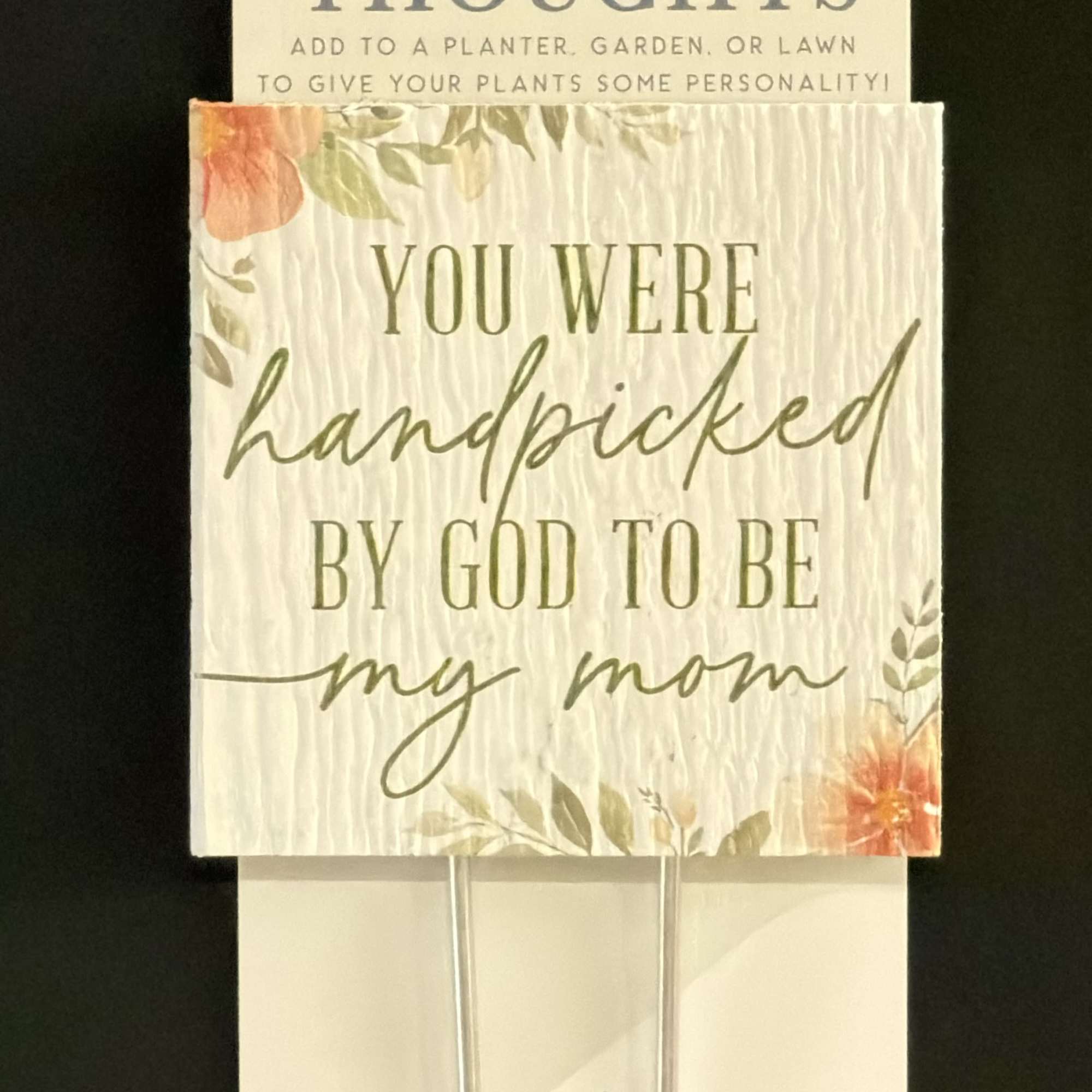 Two plant stake signs with floral accents and text, one reading "You were handpicked by God to be my mom"