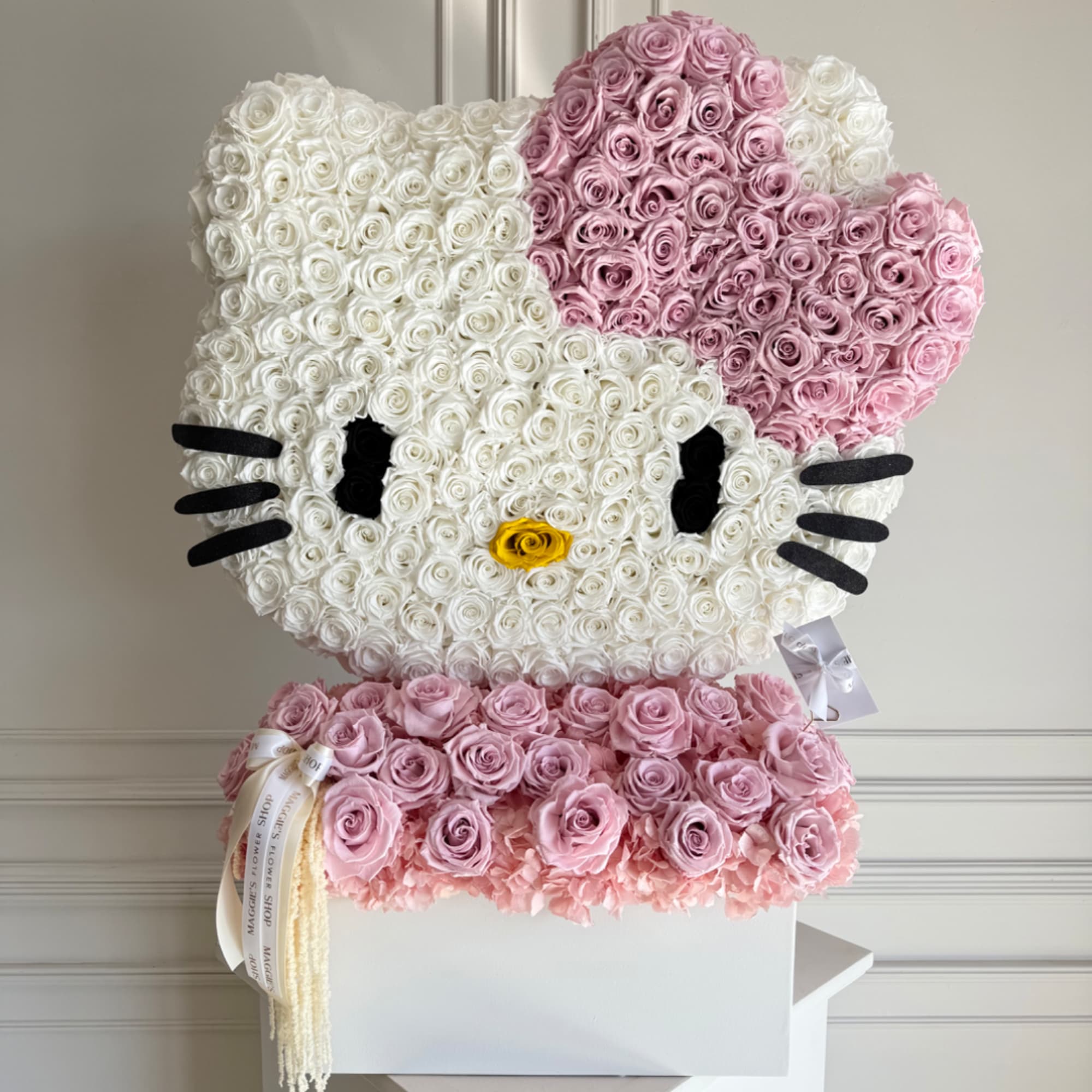 Hello Kitty-shaped rose arrangement in pink and white with a yellow nose